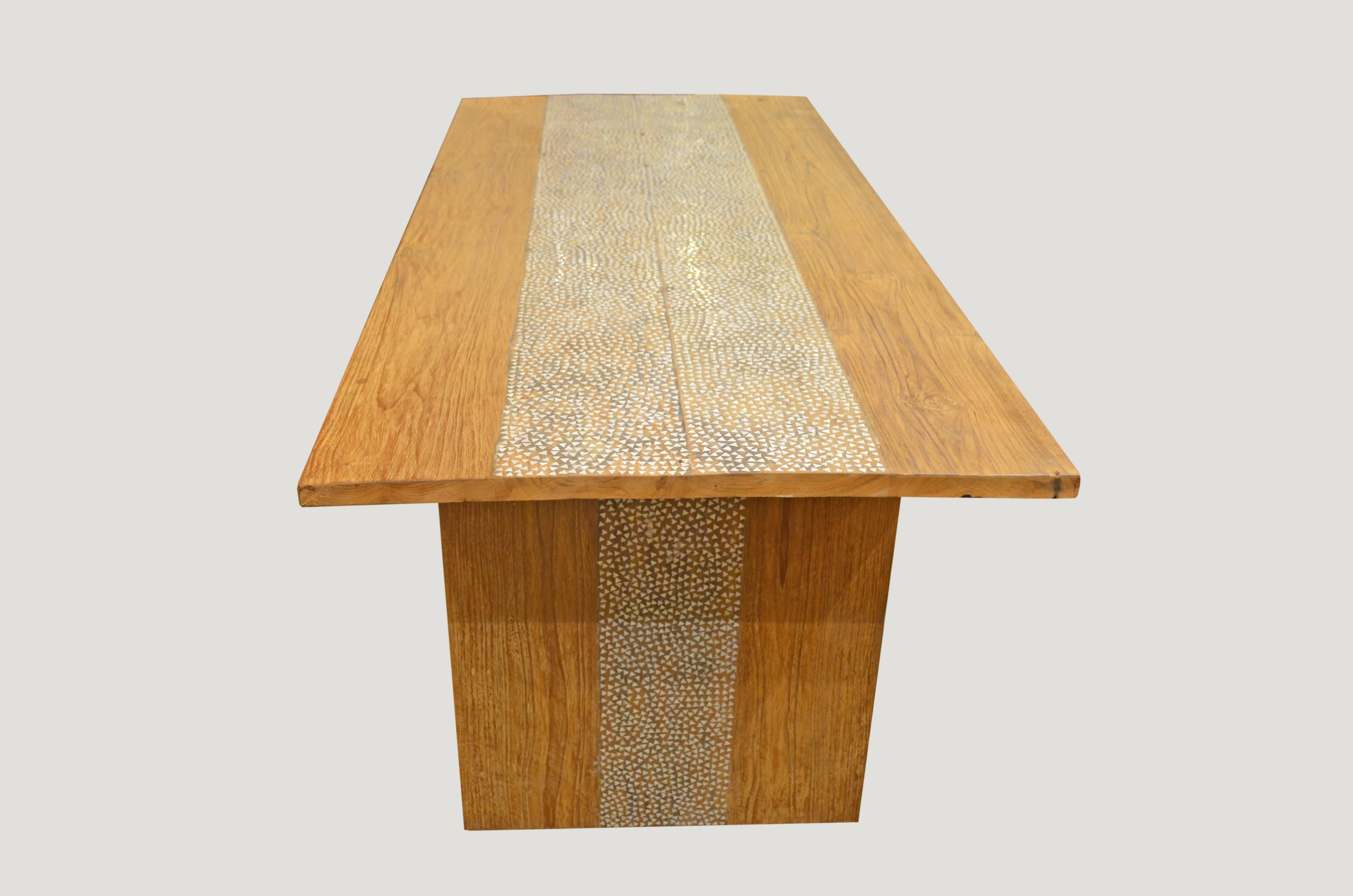 Reclaimed teak wood with added shell inlay on the top and legs. Hand cut shell is inlaid into the teak wood on this minimalist style dining table that can also be used as a desk or console.

Own an Andrianna Shamaris original.

Andrianna Shamaris,