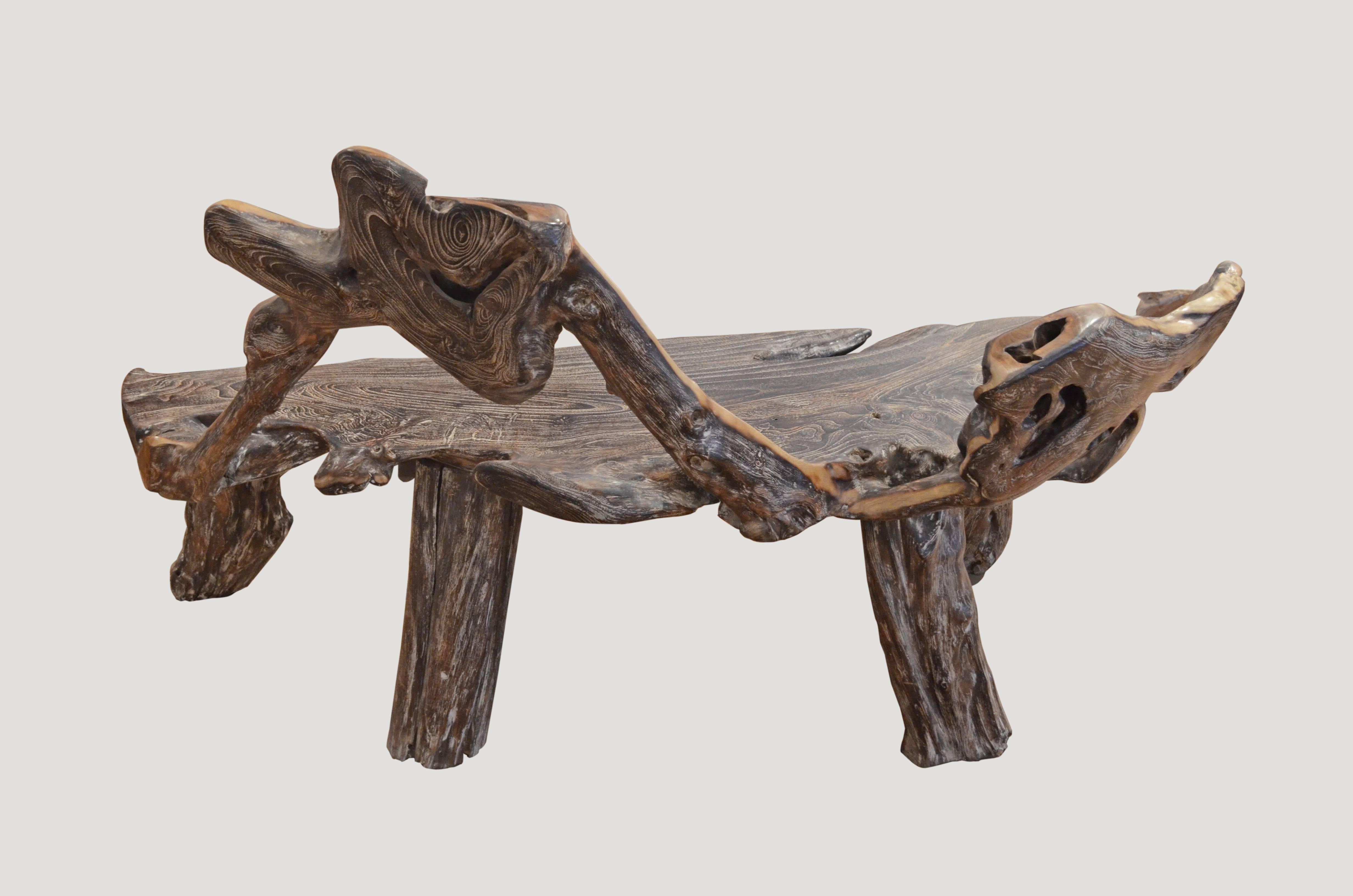 Organic shaped reclaimed teak wooden bench carved from a single piece of wood found in the jungle in Sumatra. We added the legs, burnt it one time and finally added a cerused finish. The sides are left natural teak and polished in contrast. Organic