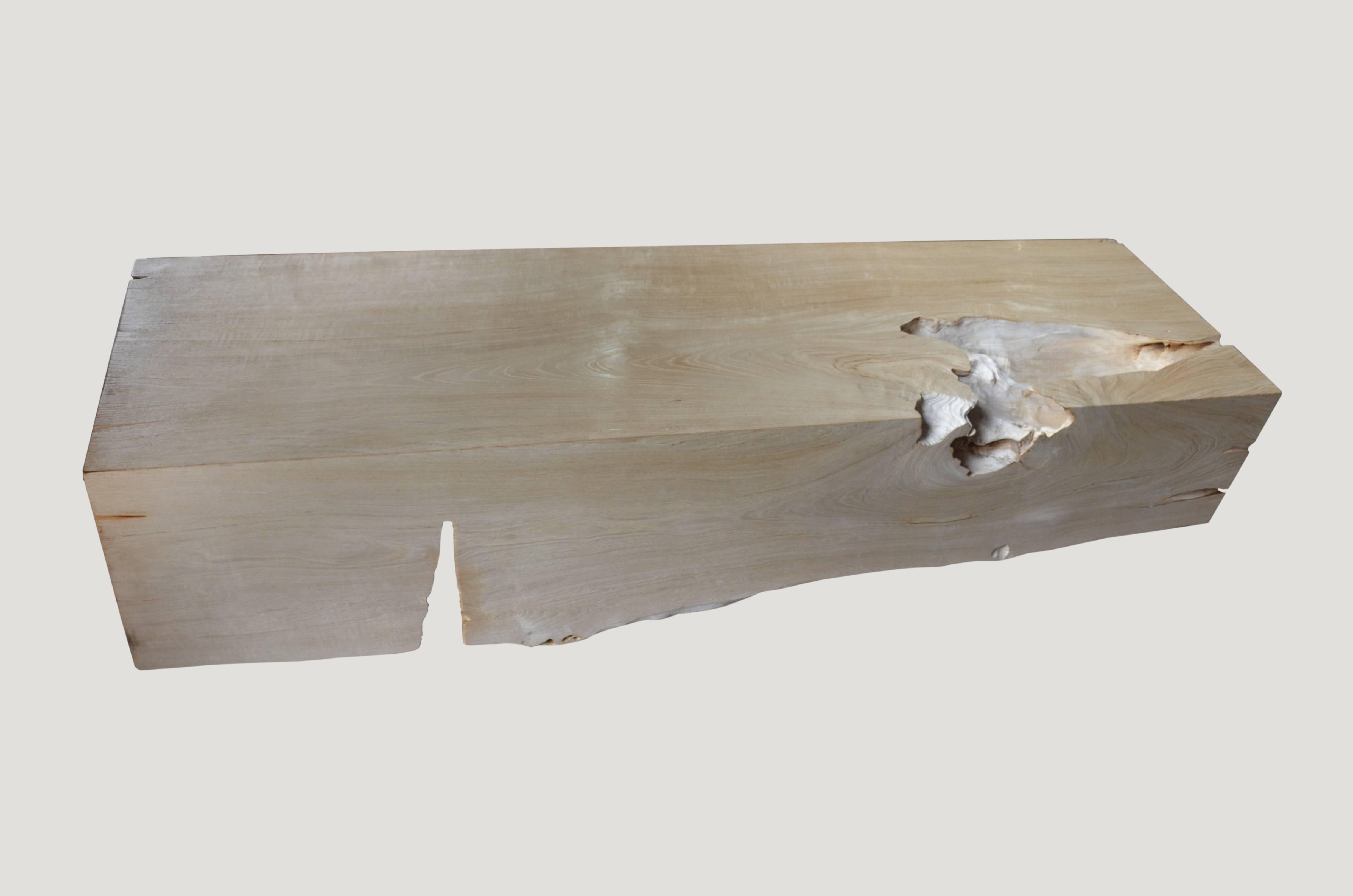 Impressionnant banc en bois de teck à une seule racine. Le teck récupéré est blanchi et laissé à cuire au soleil et à l'air salin pendant plus d'un an pour obtenir cette finition unique. Nous avons ajouté un léger shellack sur la partie supérieure