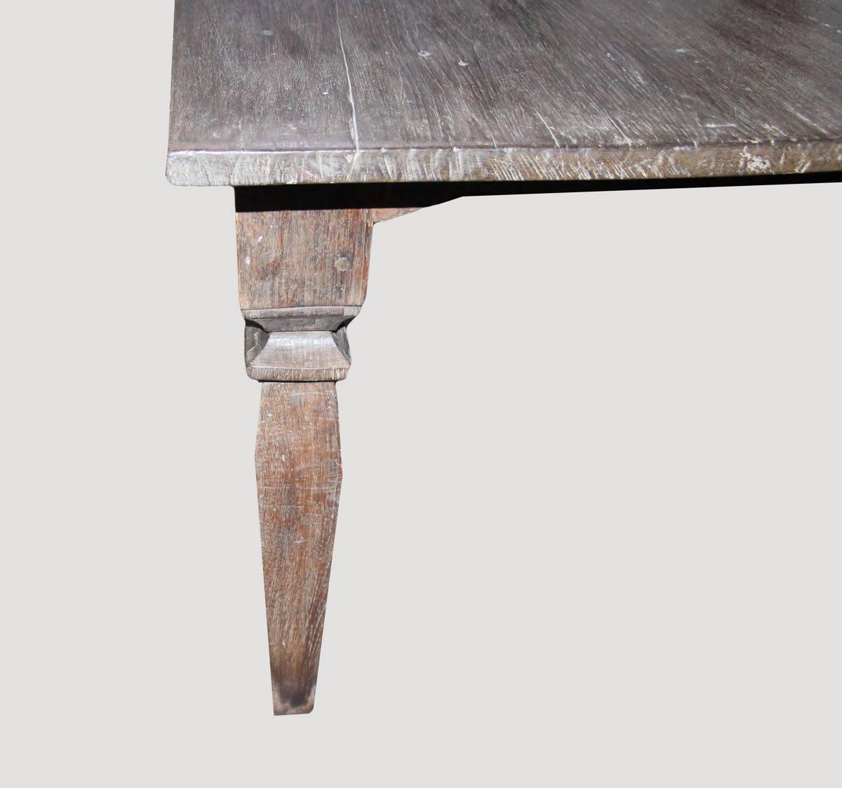 Beautiful patina on this stunning Andrianna Shamaris teak wood dining table with hand-carved legs. The top consists of two slabs.

This side table was sourced in the spirit of wabi-sabi, a Japanese philosophy that beauty can be found in imperfection
