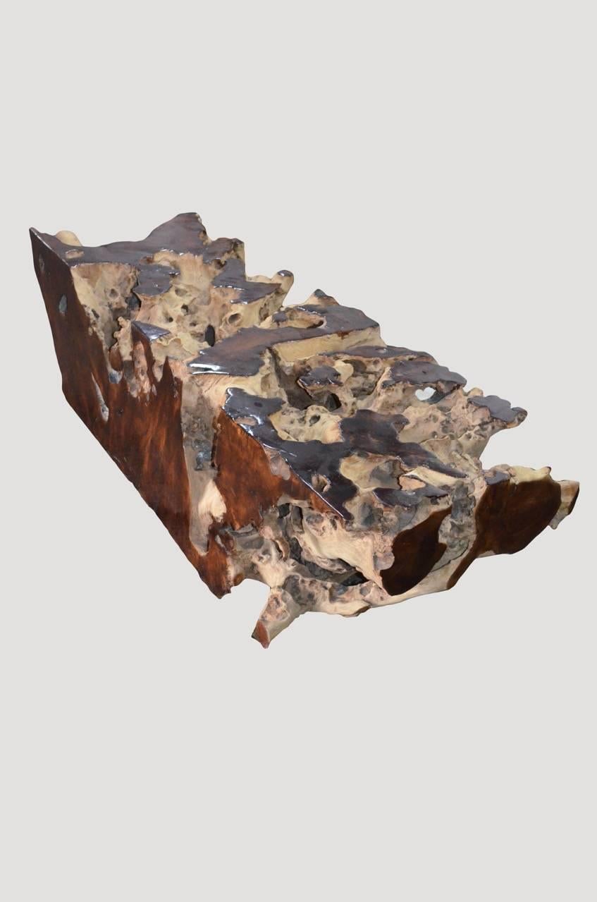 Organic formed teak wood root coffee table. This piece is a cross section taken from the root of a large tree. A combination of raw teak on the outer layer with a sanded and polished teak top. Perfect with a glass or Lucite top.

Andrianna Shamaris.
