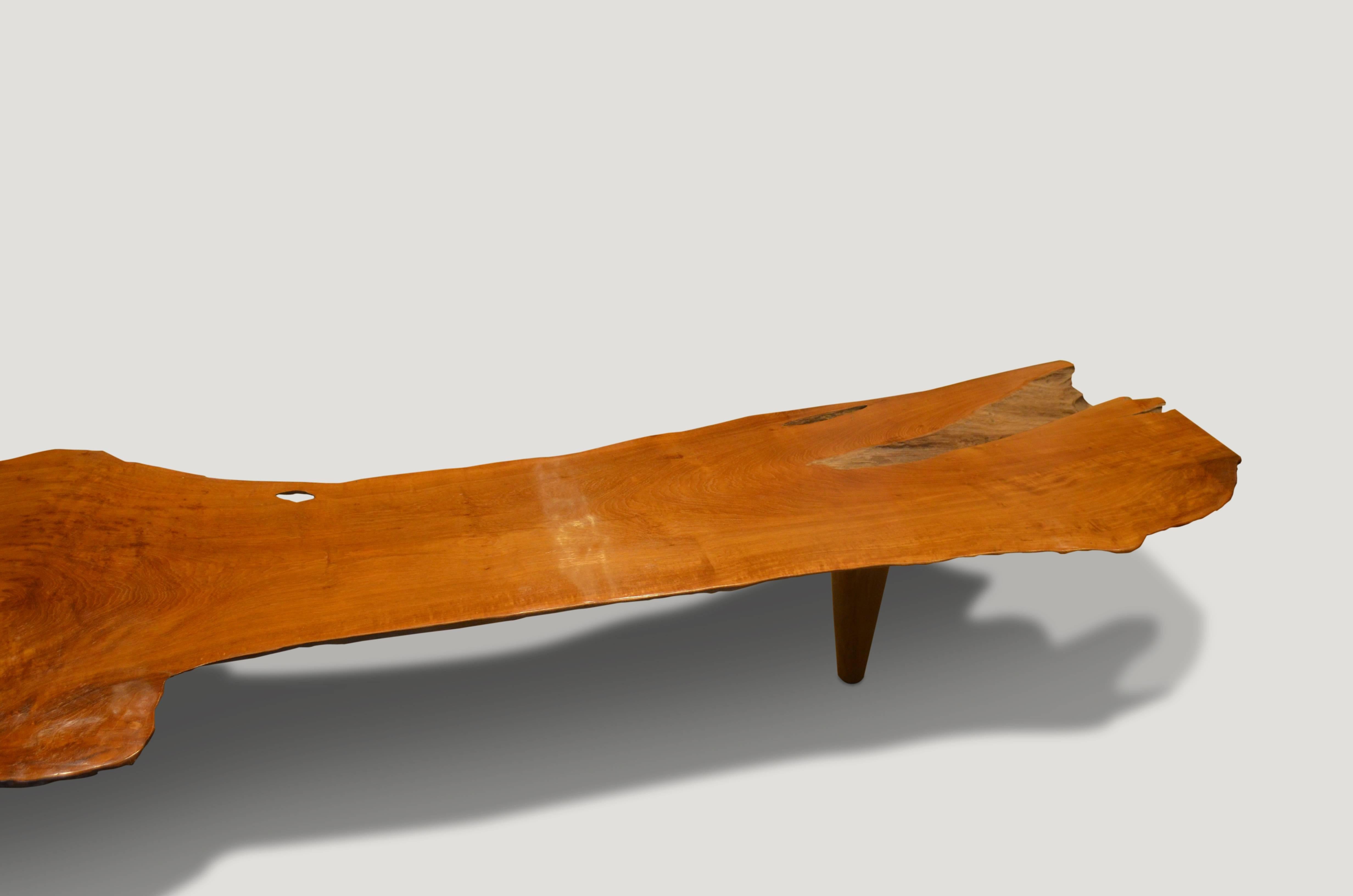 Impressive 5” single teak wood slab top coffee table of bench. We have added midcentury style legs to this stunning organic shape and polished the top to enhance the grain in the reclaimed teak wood, whilst leaving sections of the sides raw for an