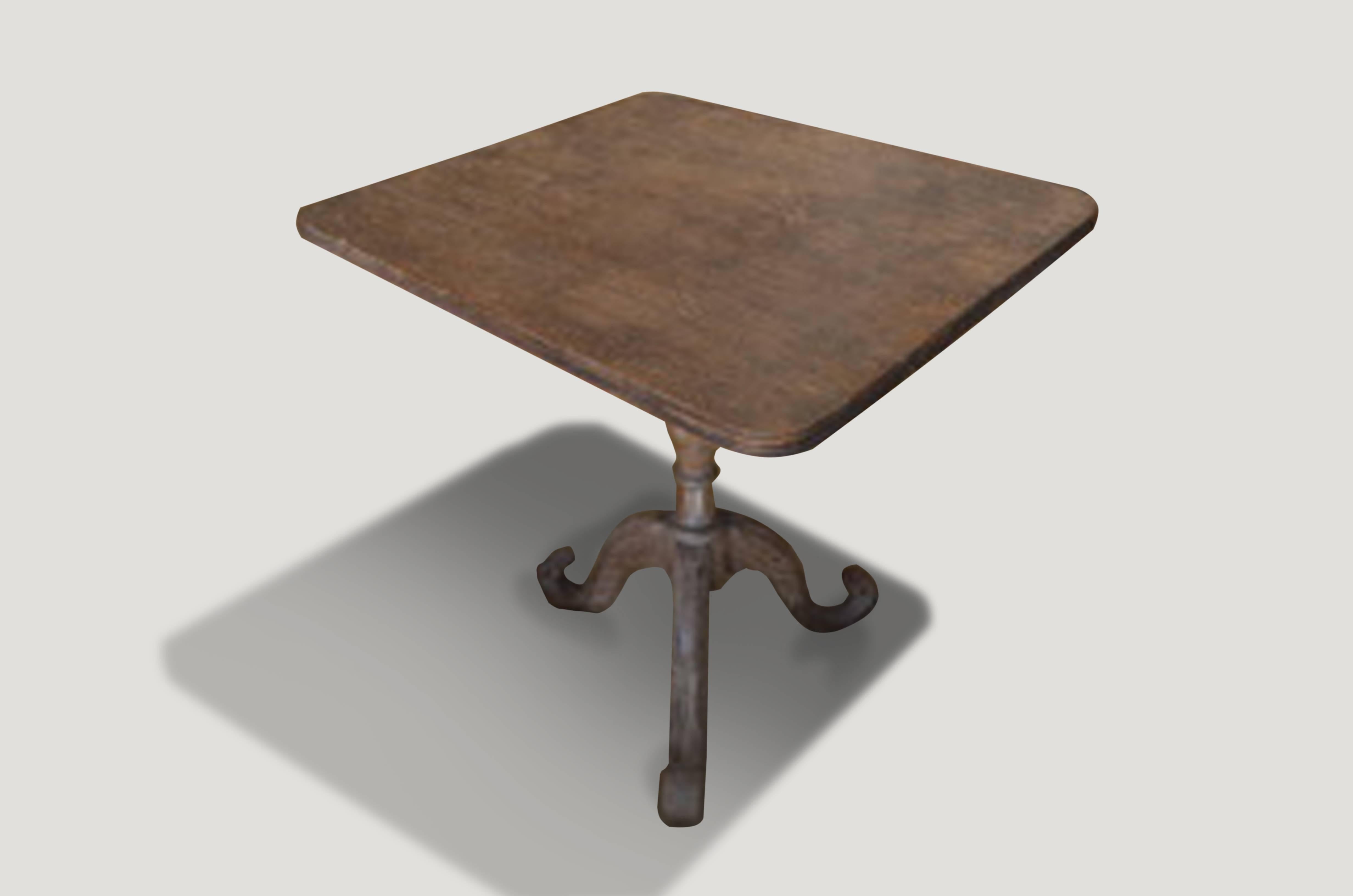Beautiful, hand-carved antique teak wood table from Madura. The top is cut from a single slab with a hand-carved bevelled edge. The base is also hand-carved with stunning detail. Large enough for dining for two a game table, or perfect as a side