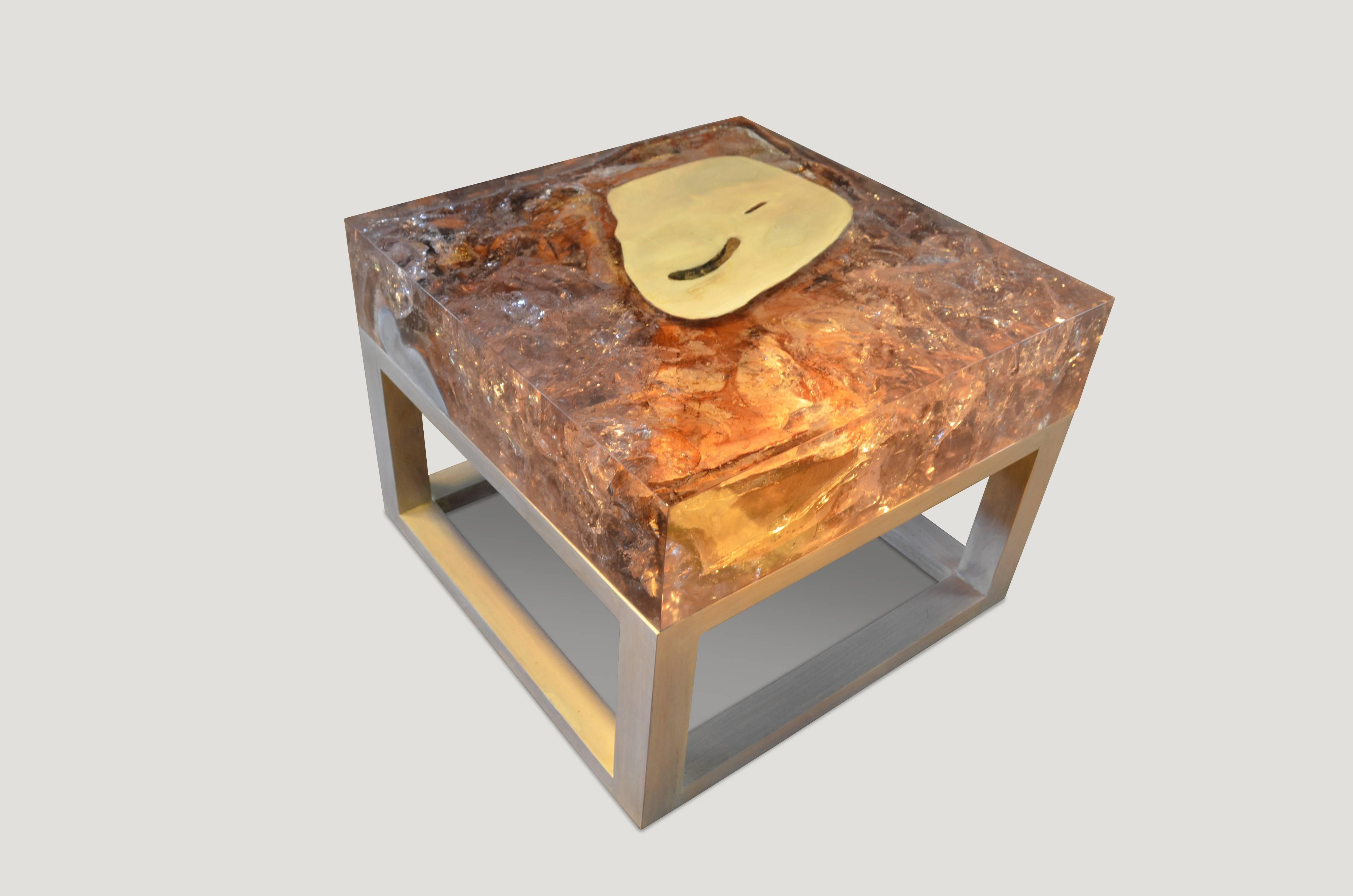 This cracked resin side table or coffee table is made from reclaimed teak infused with clear resin, which resembles a unique quartz crystal with many different facets, as shown here with gold, warm tones created naturally from the wood. Straight