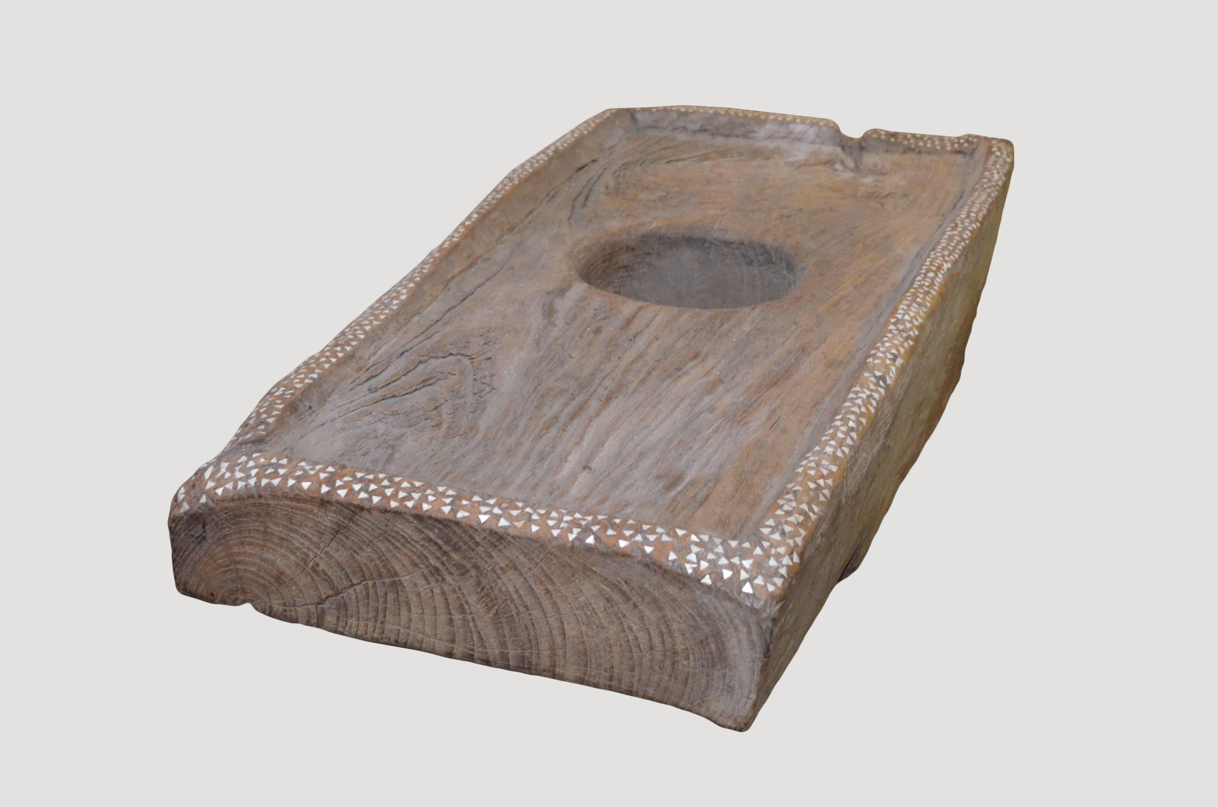 Originally used as a rice pounder. Carved from a single teak slab with added shall inlay. Great with a glass or Lucite top as coffee or side table.