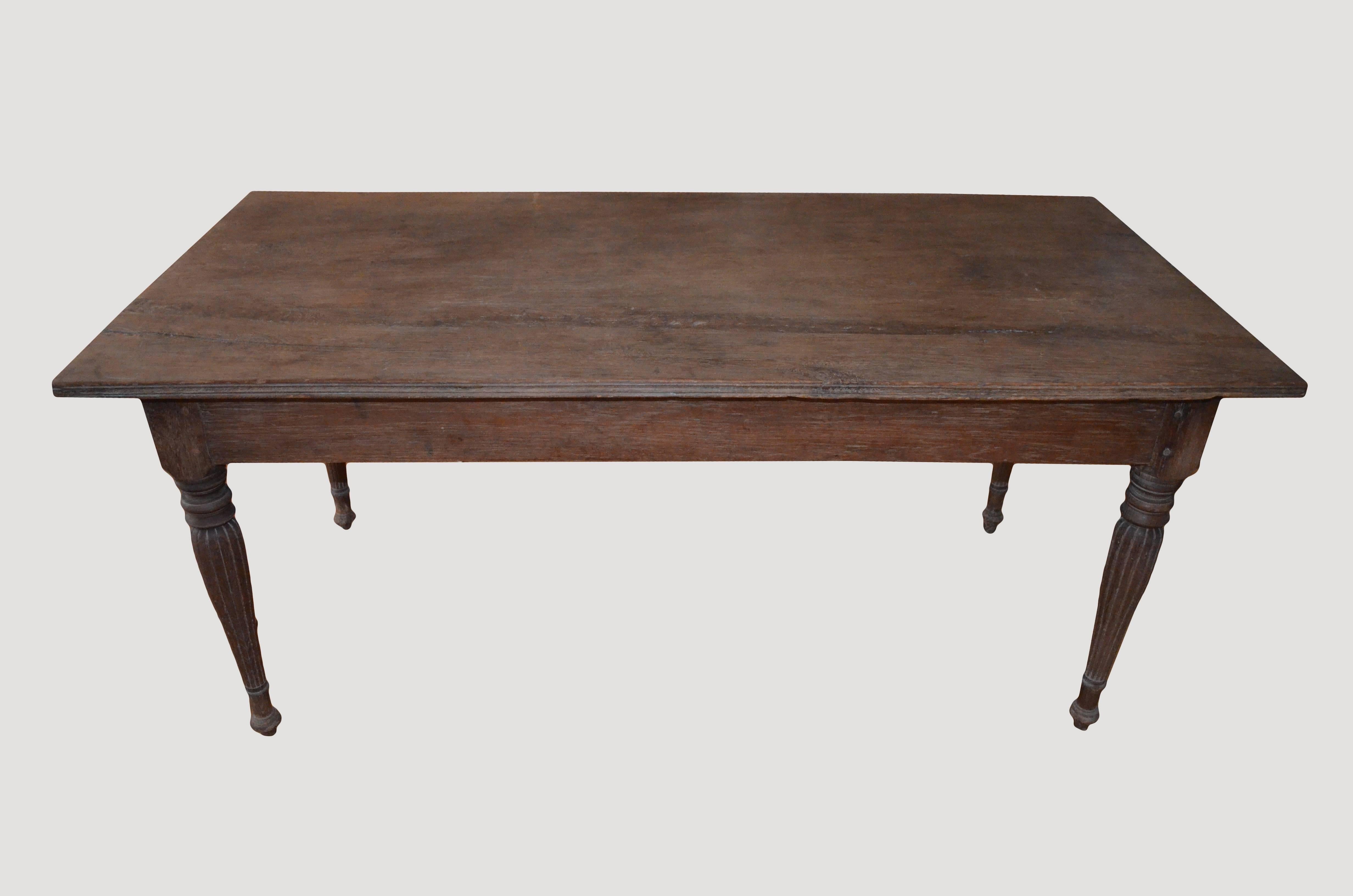 Single slab antique Raffles teak wood desk with a hand-carved bevelled edge. Beautiful hand-carved legs with two drawers. Perfect also as a small dining table or entrance table.

This table was sourced in the spirit of wabi-sabi, a Japanese