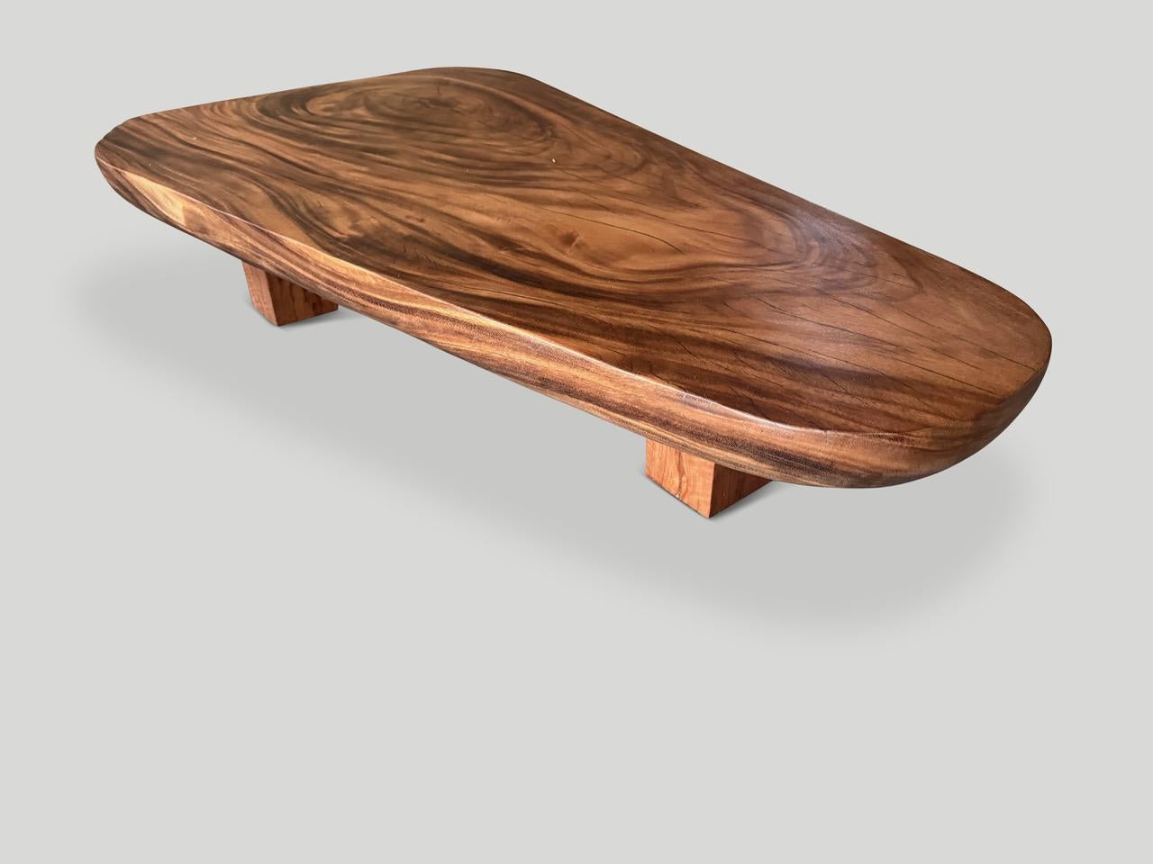 Impressionnante table basse à dalle unique de trois pouces d'épaisseur. Le bois centenaire est un rare suar noir. Nous avons ajouté trois pieds en bloc à cette table basse unique en son genre. Finition avec une huile naturelle révélant le magnifique