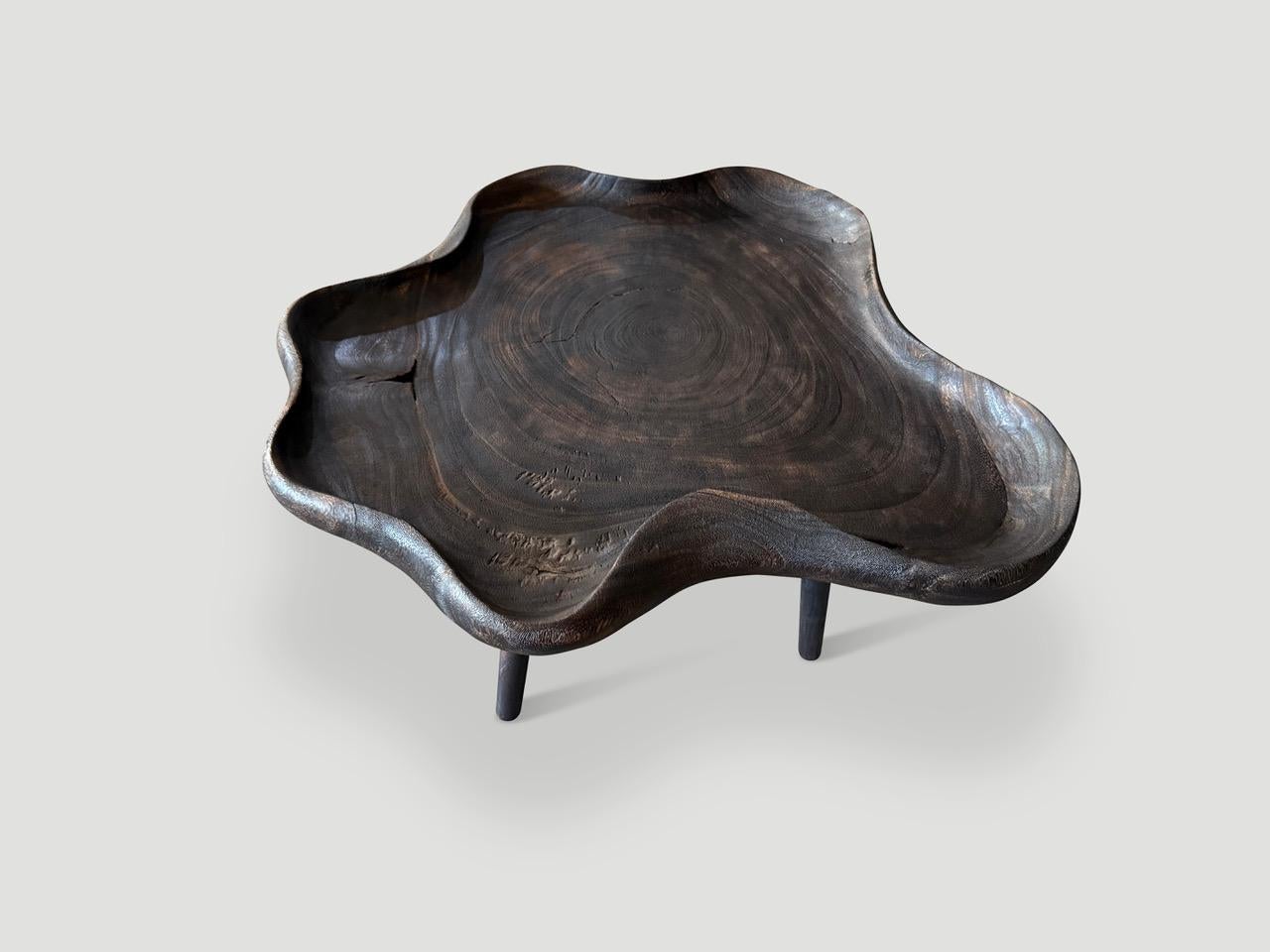 Une magnifique pièce de bois a été sculptée à la main pour produire une table basse unique avec un plateau. Nous avons ajouté des pieds cylindriques minimalistes en contraste avec ce dessus organique. Le bois a été carbonisé en un brun riche qui