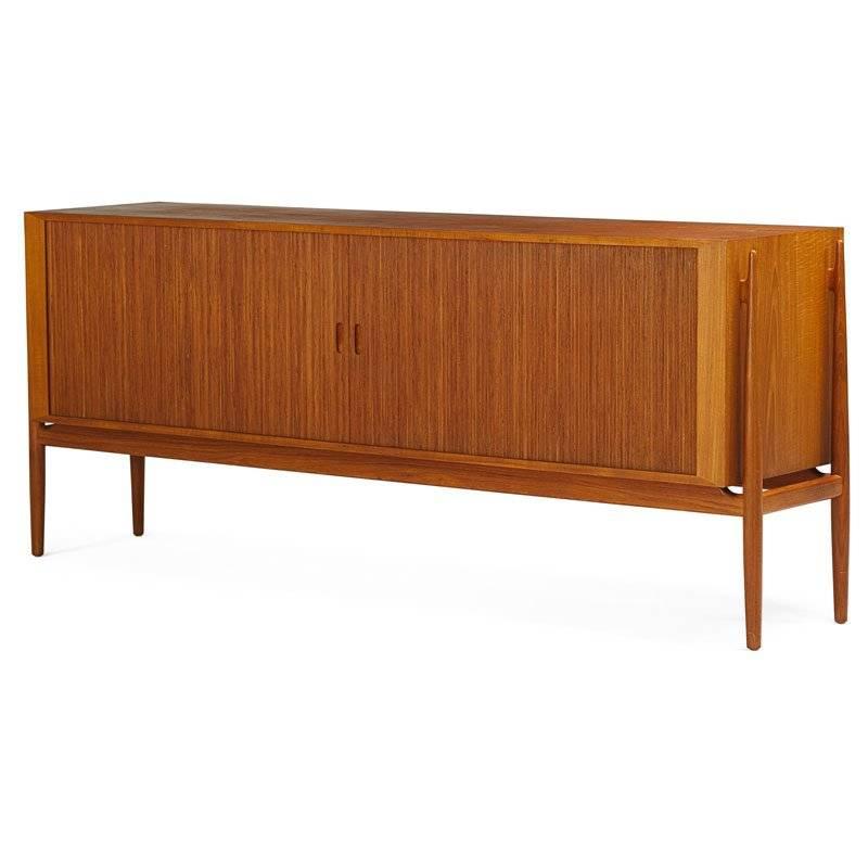 Finn Juhl NV54 sideboard with two tambour doors over eight pullout trays on left and one adjustable shelf on right. Designed, 1954.

Litterature: furnitureindex.dk, referencenr: RP02547.