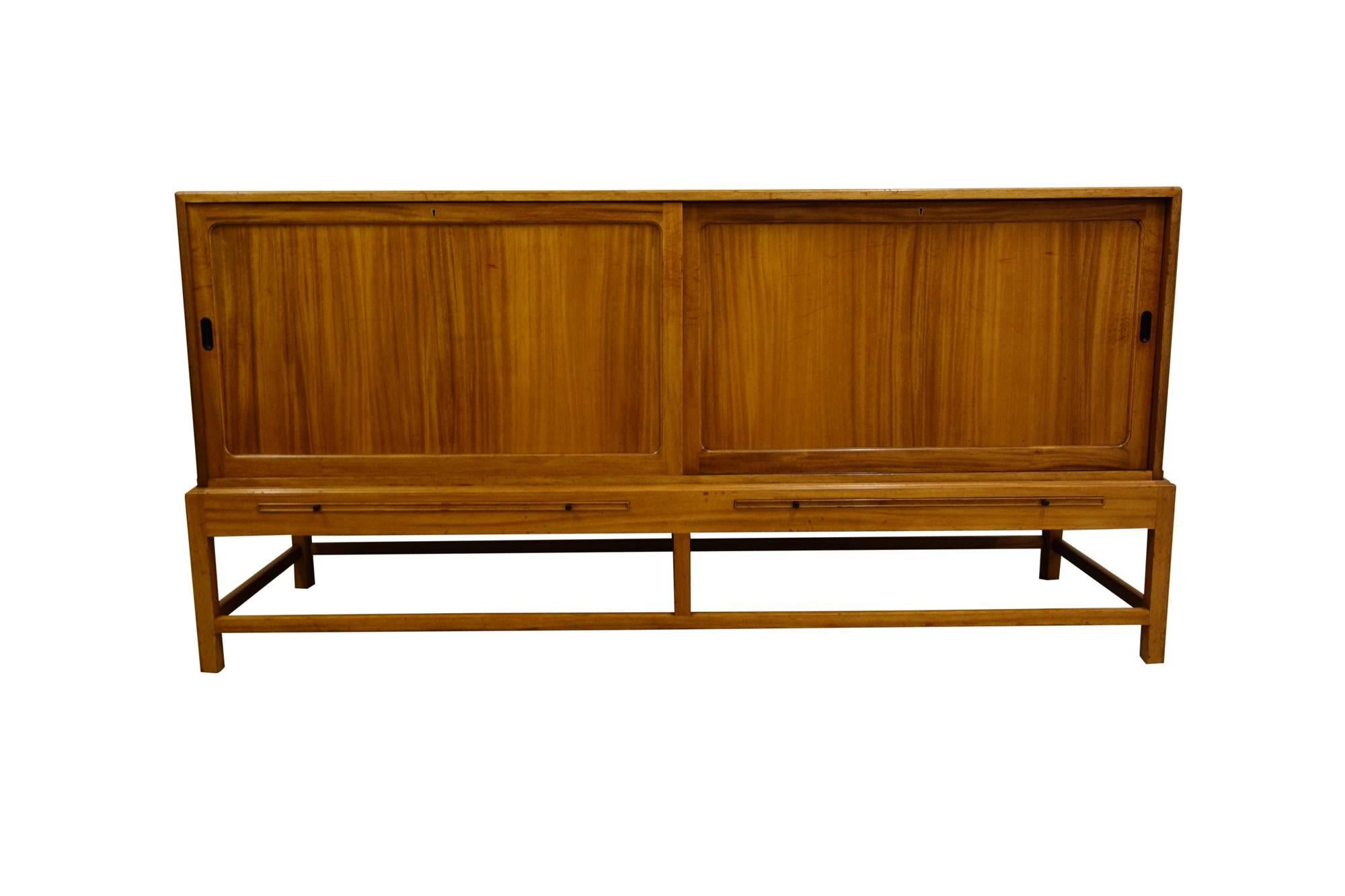 Kaare Klint sideboard in mahogany for Rud Rasmussen cabinetmakers, Copenhagen. Sideboard features two sliding doors concealing storage with eleven removable trays.

Signed with decal manufacturer's label to reverse: [Rud Rasmussens Snedkerier 45