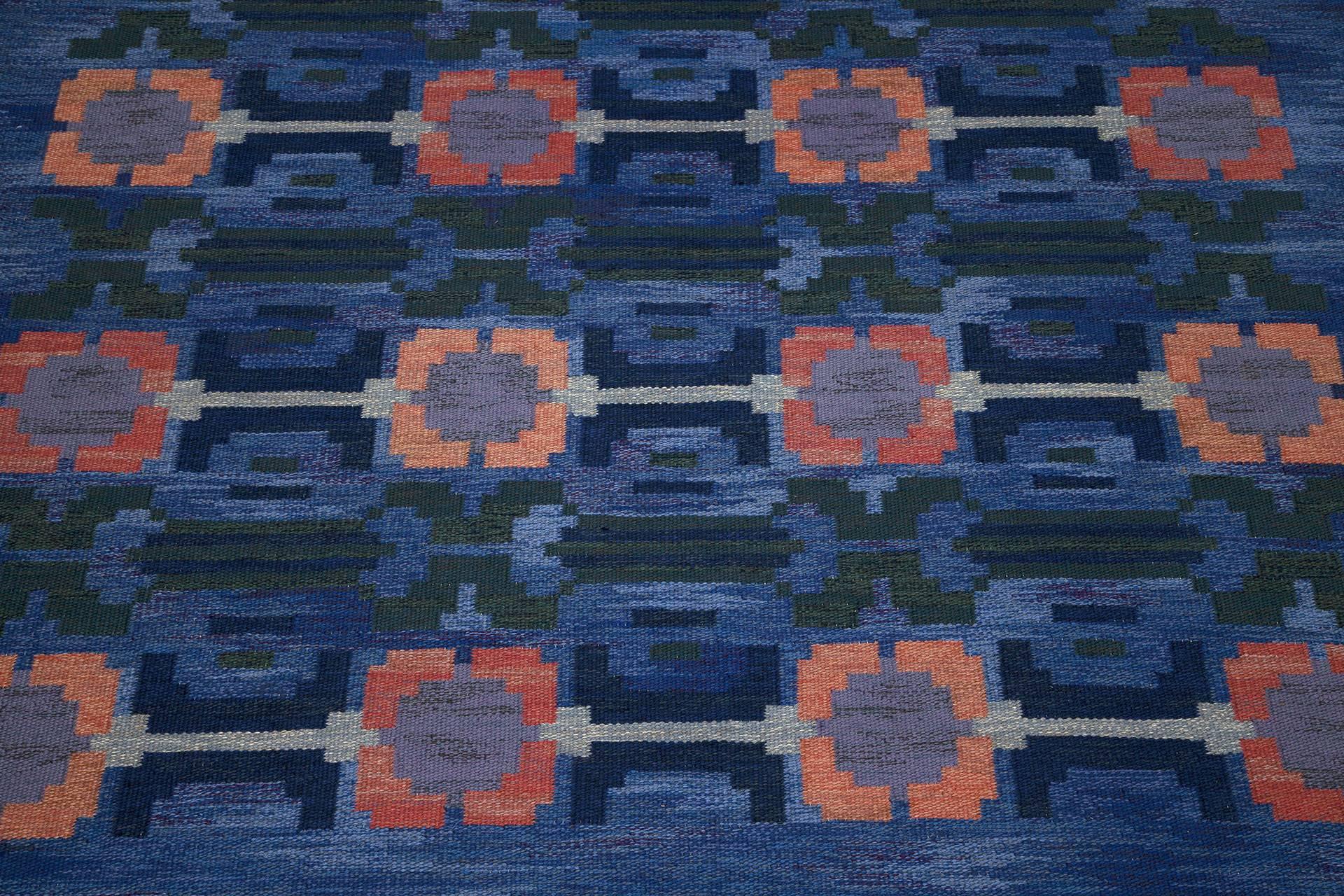 Flat-weave carpet by Judith Johansson titled 'Vallmovång'. Handwoven wool carpet in "rölakan" flat-weave technique. Blue base decorated with polychrome stylized poppies and leaves. Signed monogram JJ. Designed 1961.

This example is