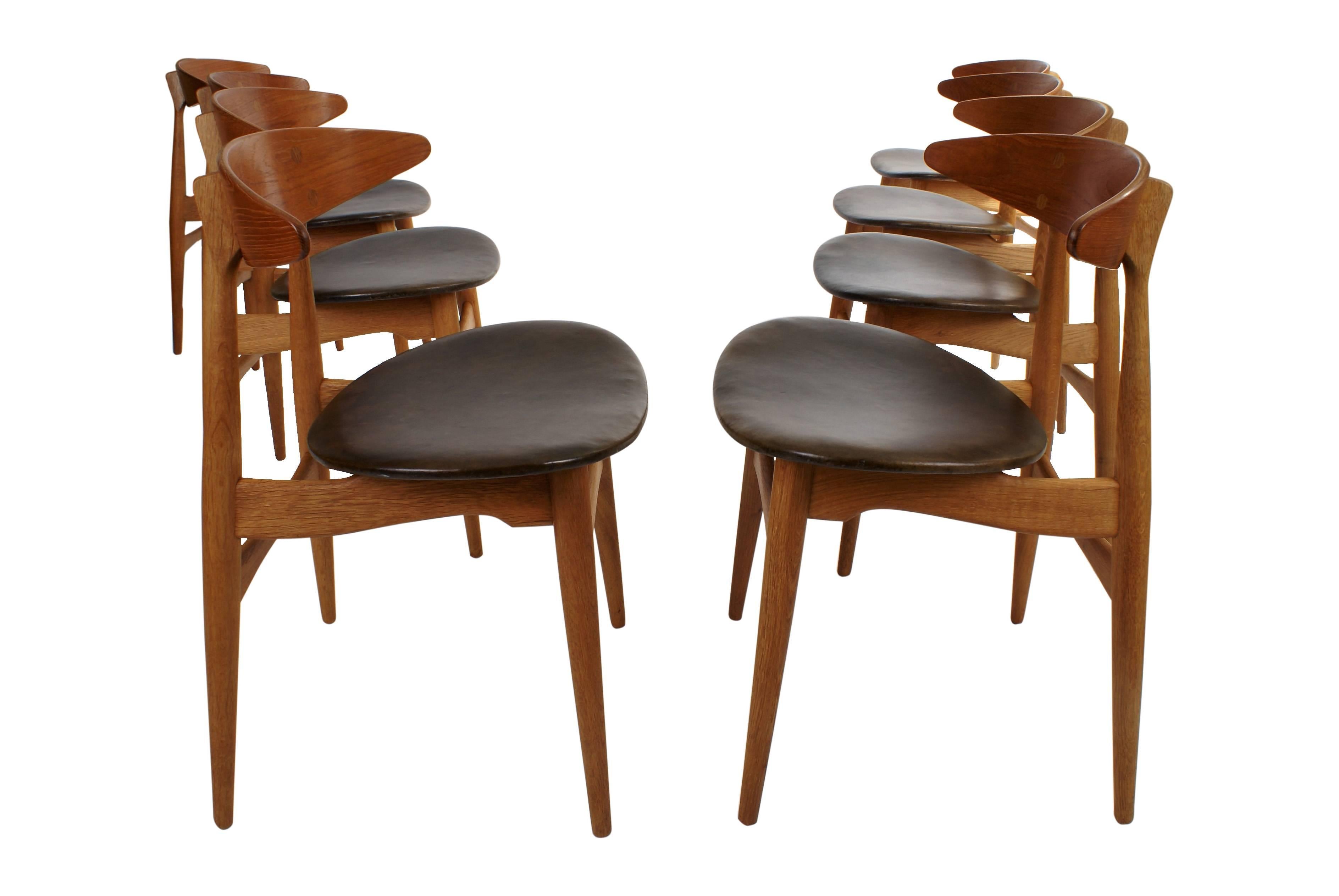 Set of eight Hans Wegner 'CH 33' dining chairs. Backrests are in molded teak on oak frames. Original black leather upholstery. Designed 1957. Manufactured by Carl Hansen. & Søn. All chairs stamped from the manufacturer under seat.

Literature:
