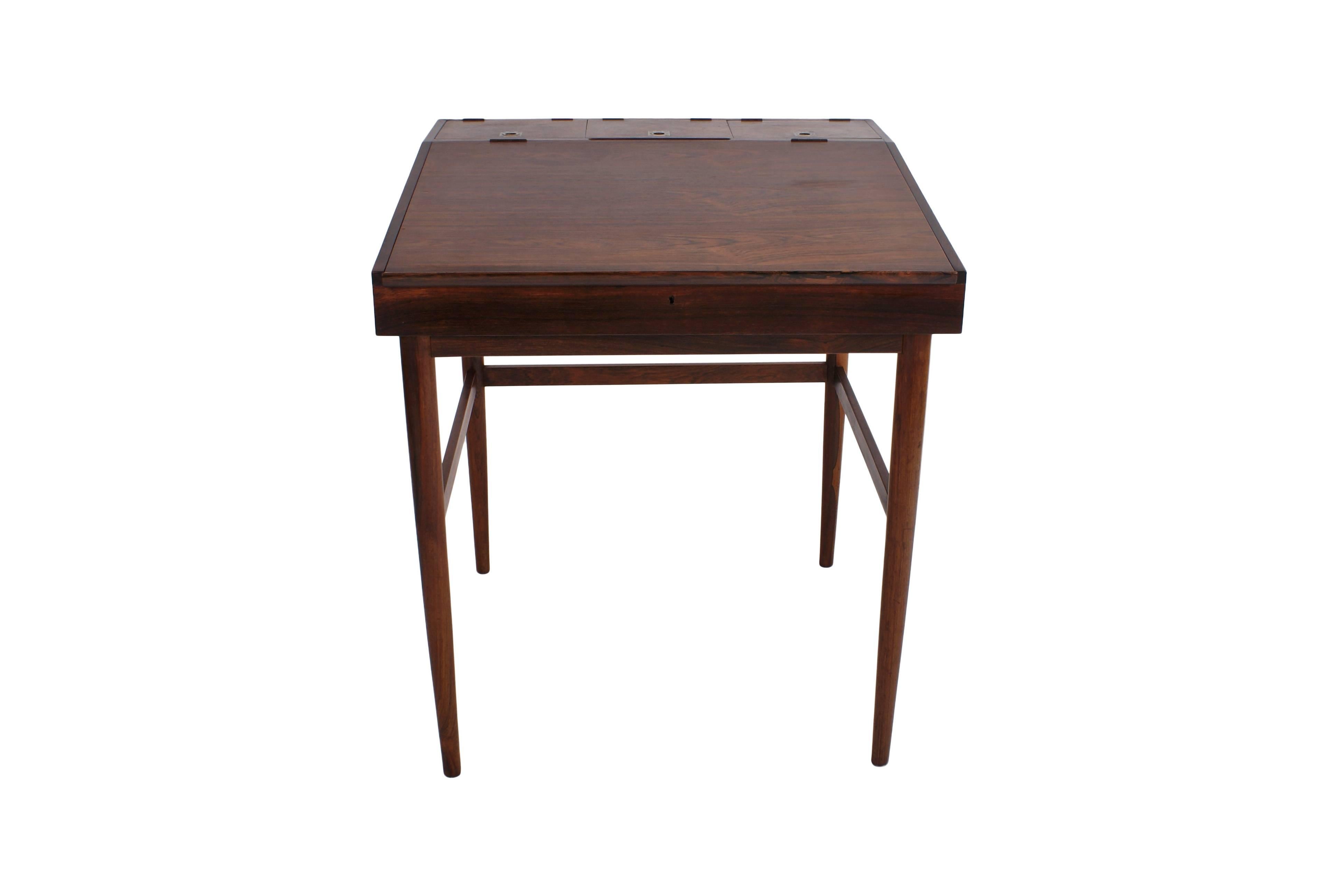 Finn Juhl writing desk in Brazilian rosewood for cabinetmaker Niels Vodder. Tapering legs. Writing top with storage space, three small compartments with lids and brass handles. Comes with key.

Stamped from cabinetmaker Niels Vodder.