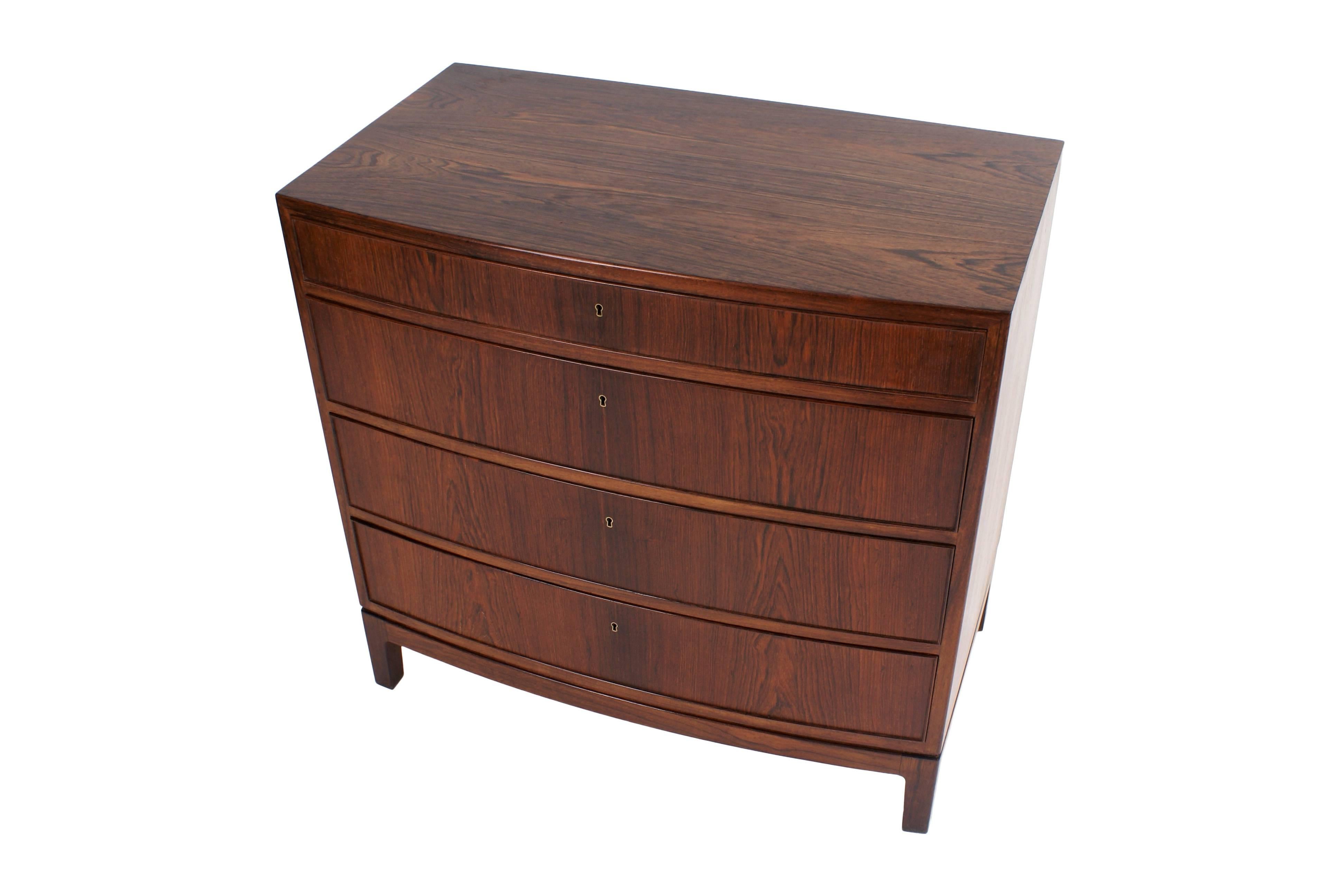 Ole Wanscher chest of drawers in Brazilian rosewood, curved front with four profiled drawers. This example made 1950-1960s by master cabinetmaker A.J. Iversen. Comes with key.