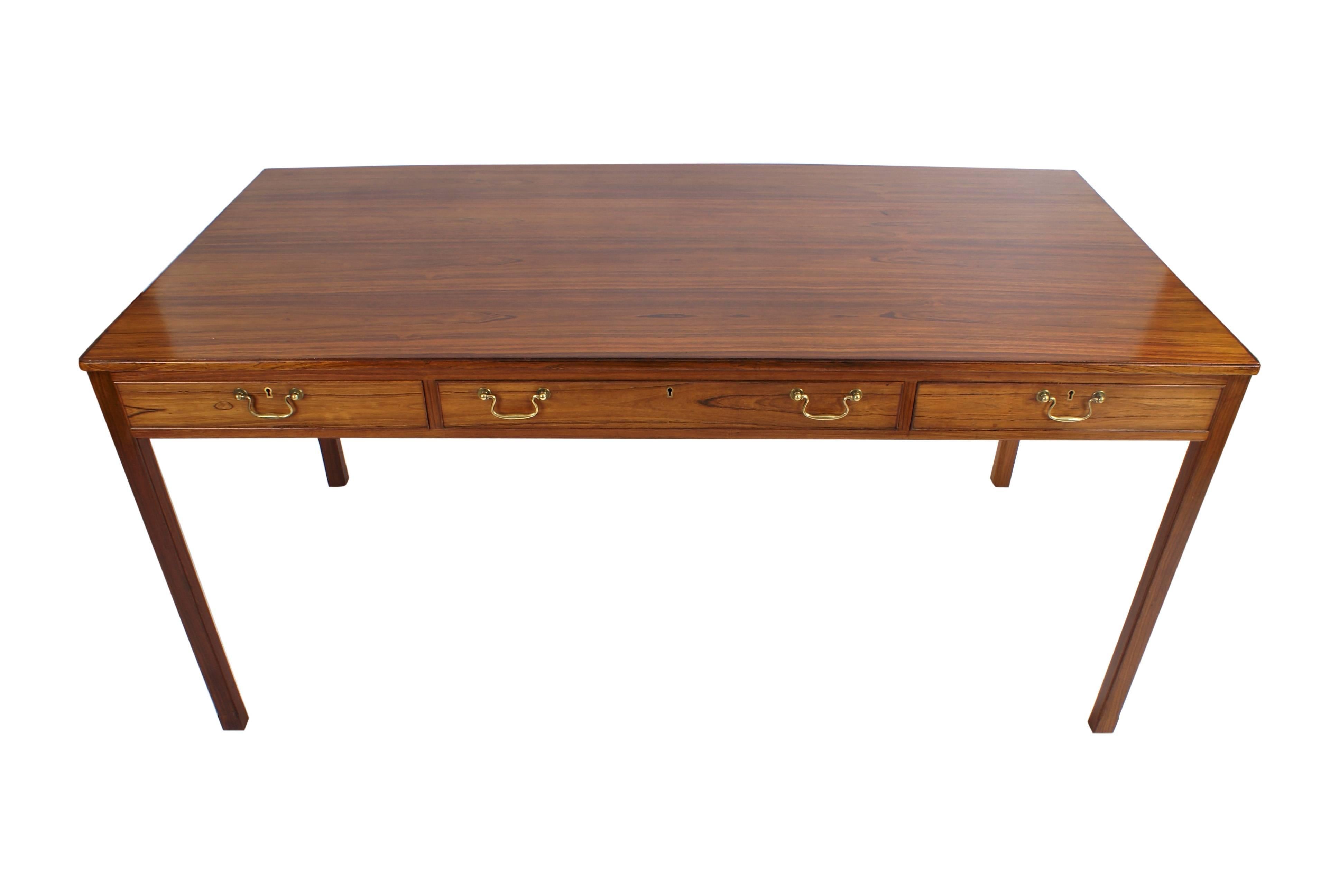 Jacob Kjaerr, freestanding Brazilian rosewood desk, front with three profiled drawers in rail, handles of brass. This example made 1950s by master cabinetmaker Jacob Kjaer. With paper label from Jacob Kjaer. Comes with key.