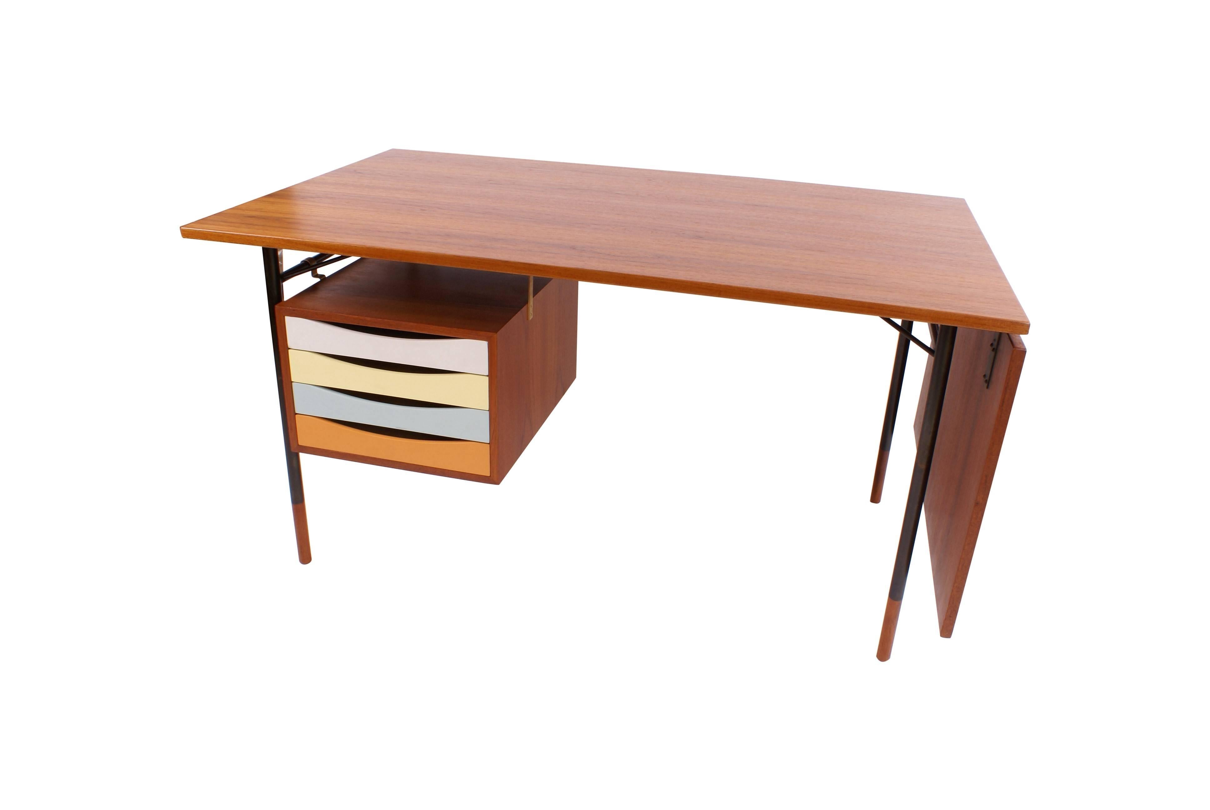 Finn Juhl freestanding teak writing desk with detachable flip-down leaf. Drawer section with four polychrome lacquered drawers. Anodized metal frame with teak shoes. Designed 1953.

Literature: 