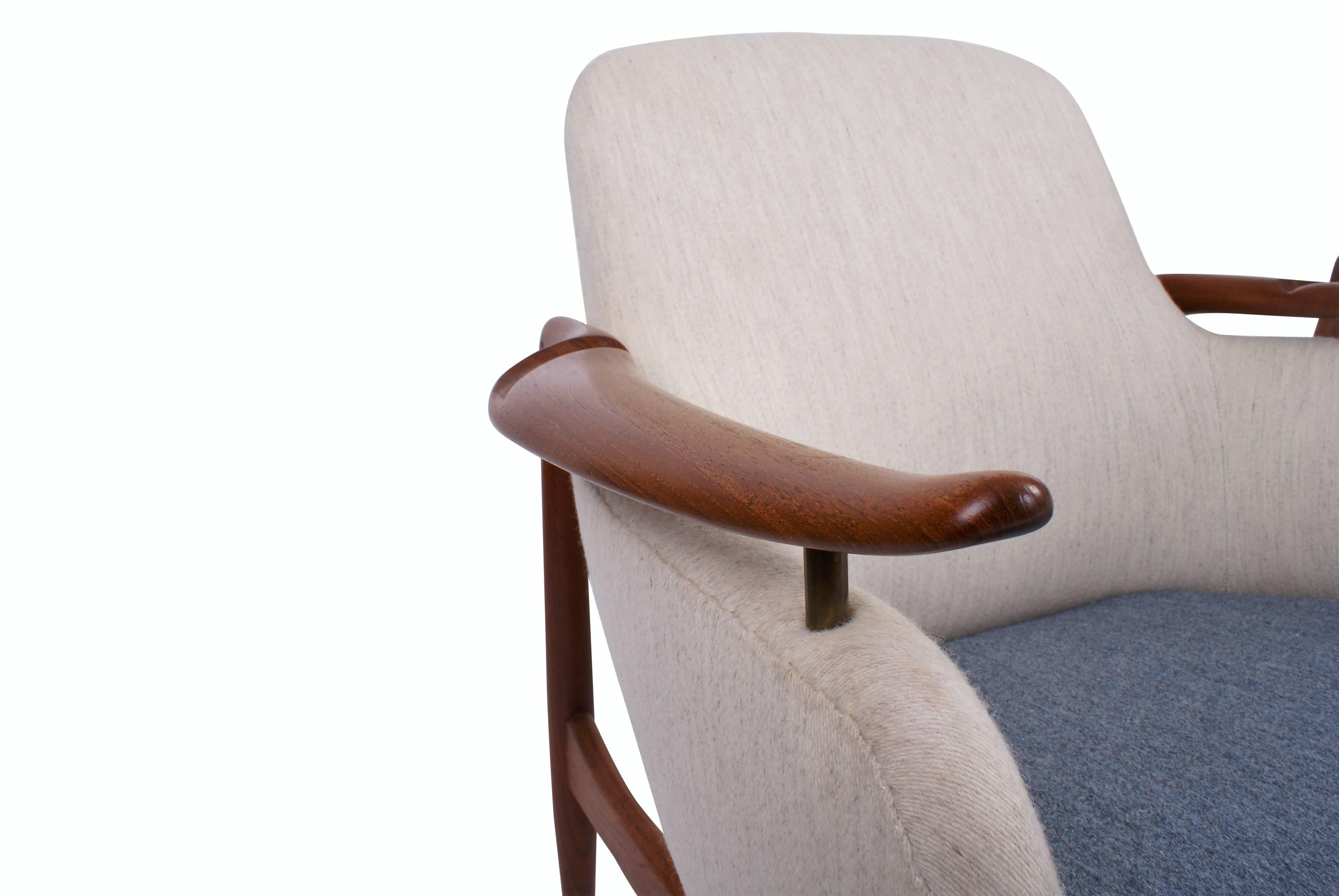 Pair of Finn Juhl NV53 easy chairs in teak with floating armrests, mounted with brass fittings. Seat, sides and back re-upholstered with light grey and blue fabric. Designed 1953. Both chairs made and stamped by master cabinetmaker Niels