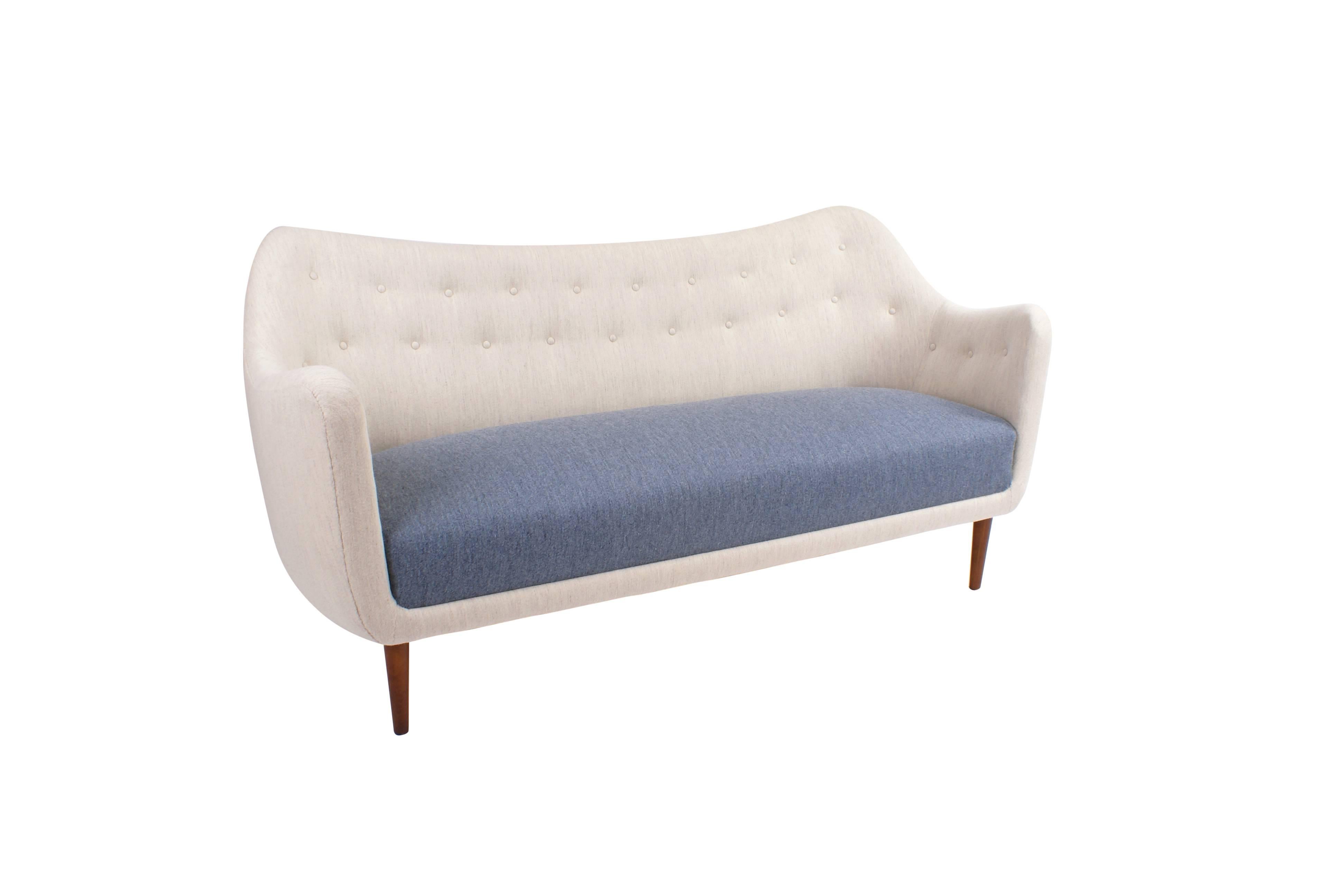 Freestanding 2.5 seater sofa with tapering, round legs. Sides and back newly upholstered in wool. Back fitted with buttons. Designed, 1946.

Literature: 