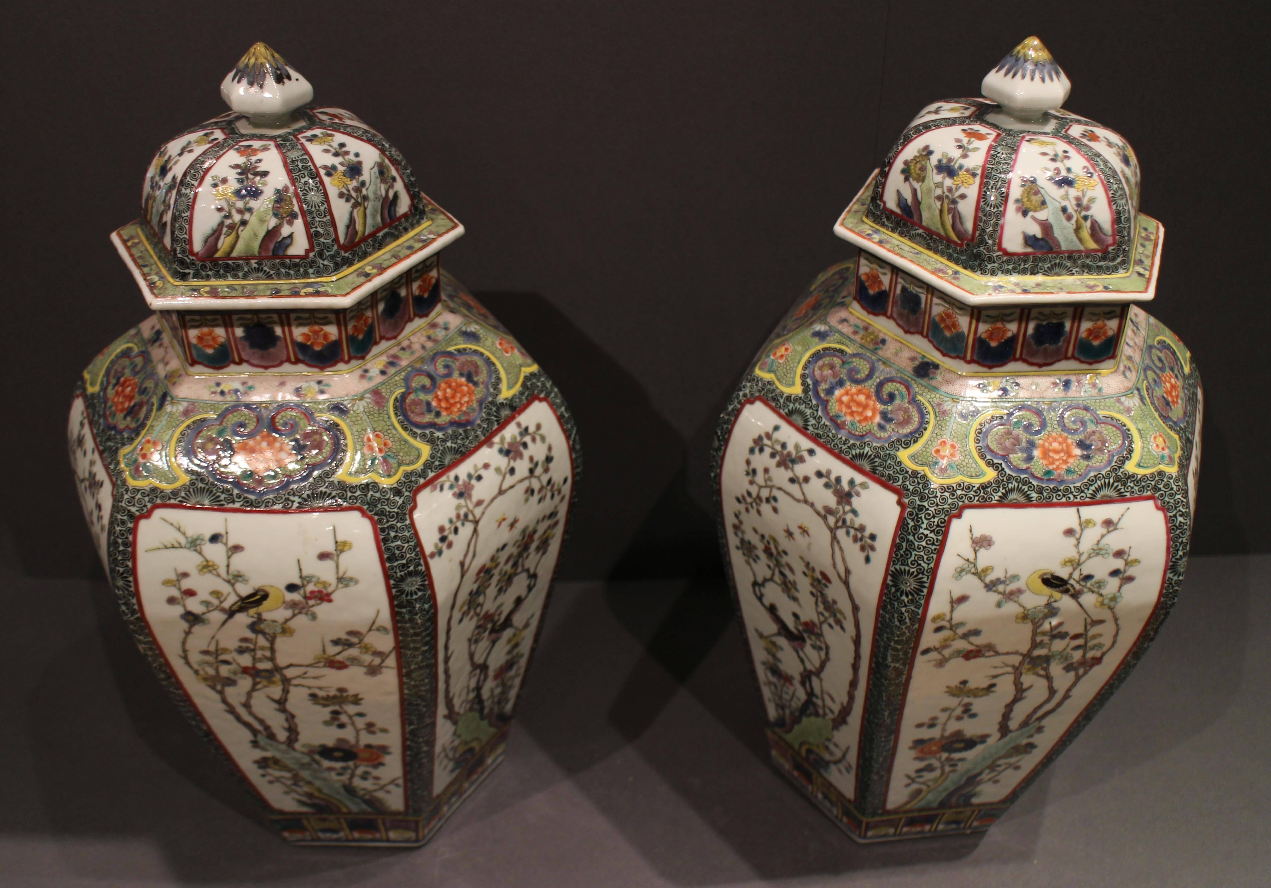 A pair of antique Chinese famille verte vases and covers, the vases are an interesting hexagonal shape, and this combined with a bold, well painted color scheme make a very striking pair of vases, they are decorated with panels of birds and