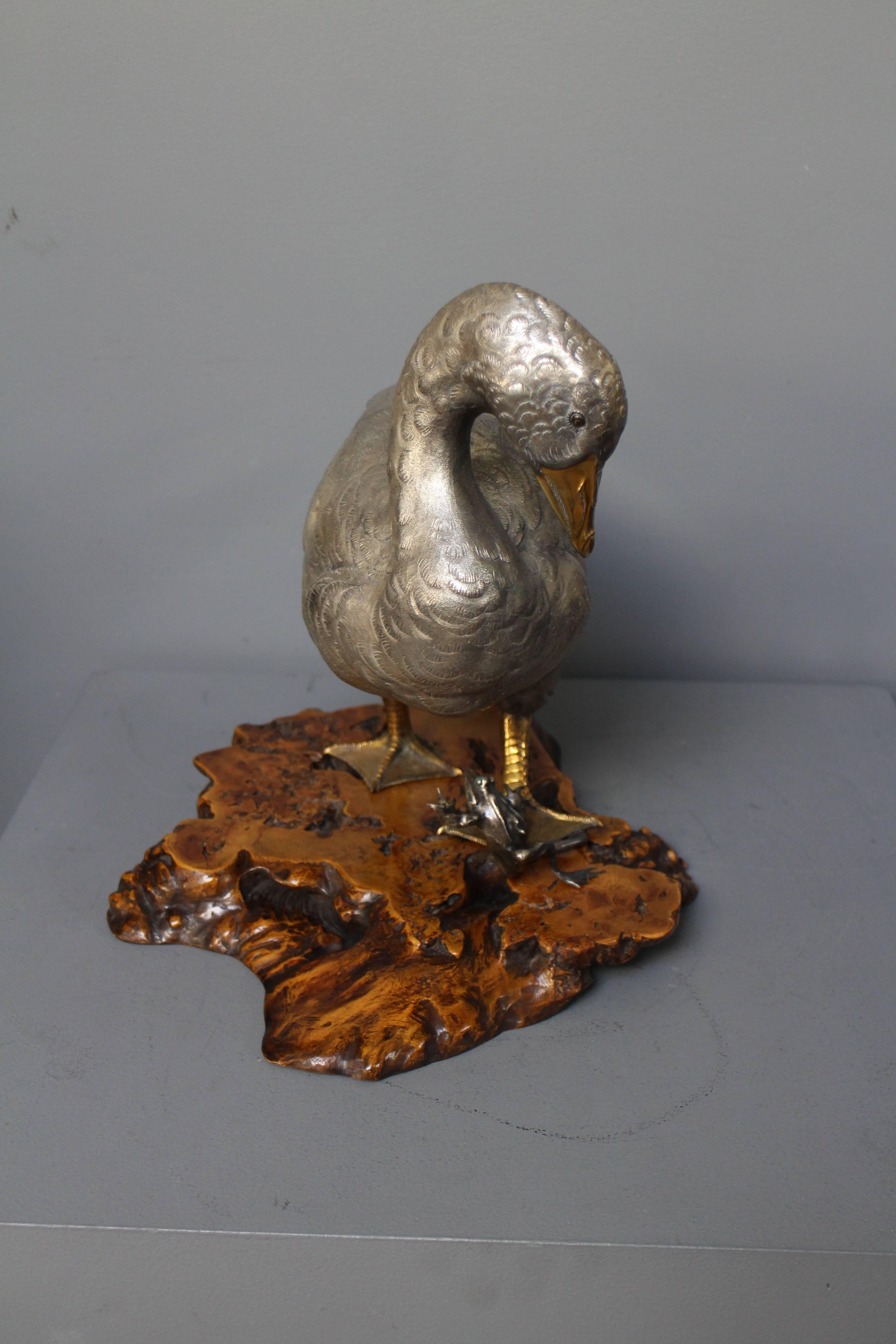 A charming realistic antique Japanese silvered and golden bronze goose on naturalistic wood base. The goose looks down at it's foot as it treads on the leg of a jumping frog. Signed Seiji

The bronze has been carefully polished with renaissance