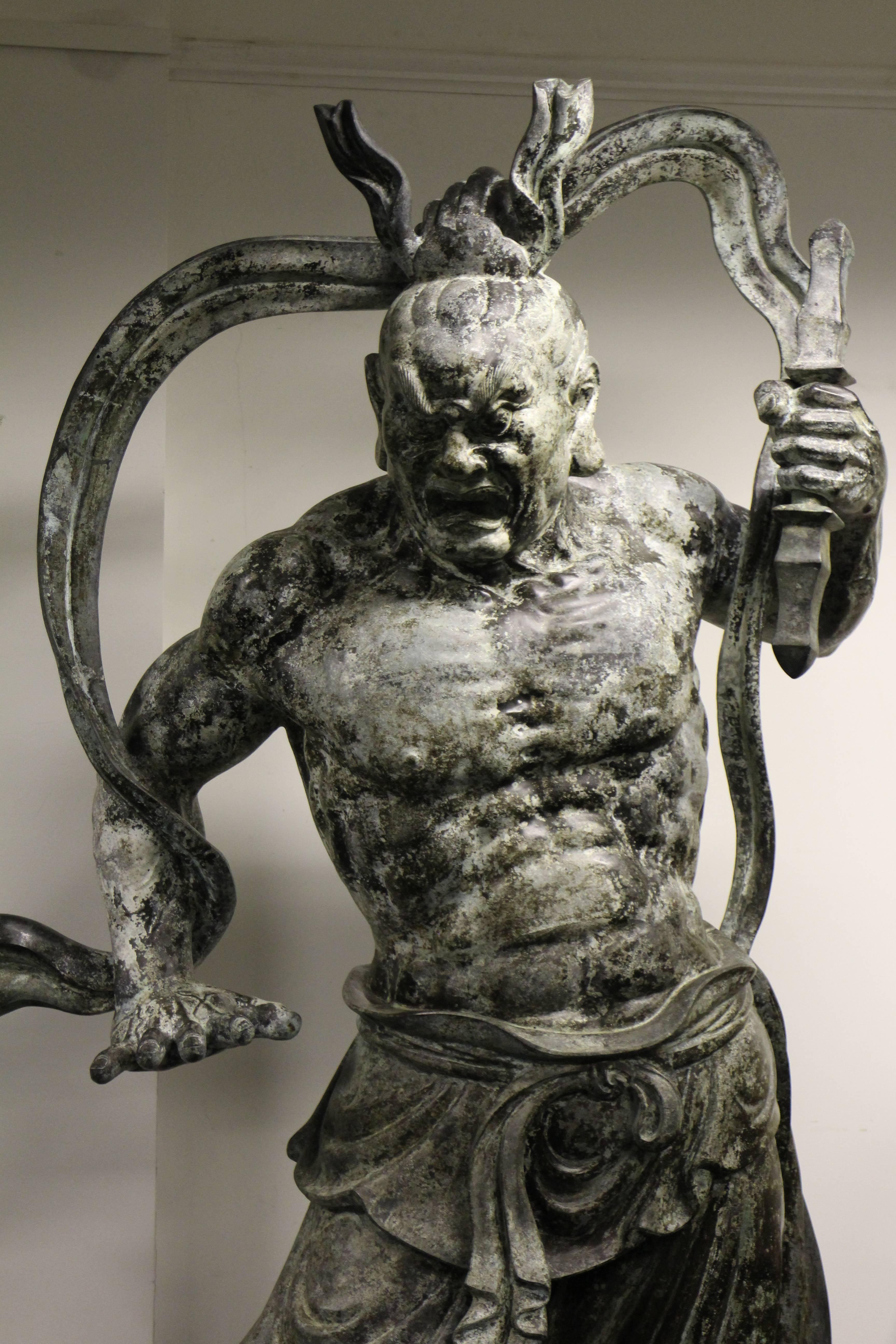 An impressive monumental pair of Japanese bronze Nio (guardian of the Buddha), the Nio are well cast and have imposing facial expressions. The left one holds a club and extends his hand denying entry, the other holds a pointed implement, his mouth