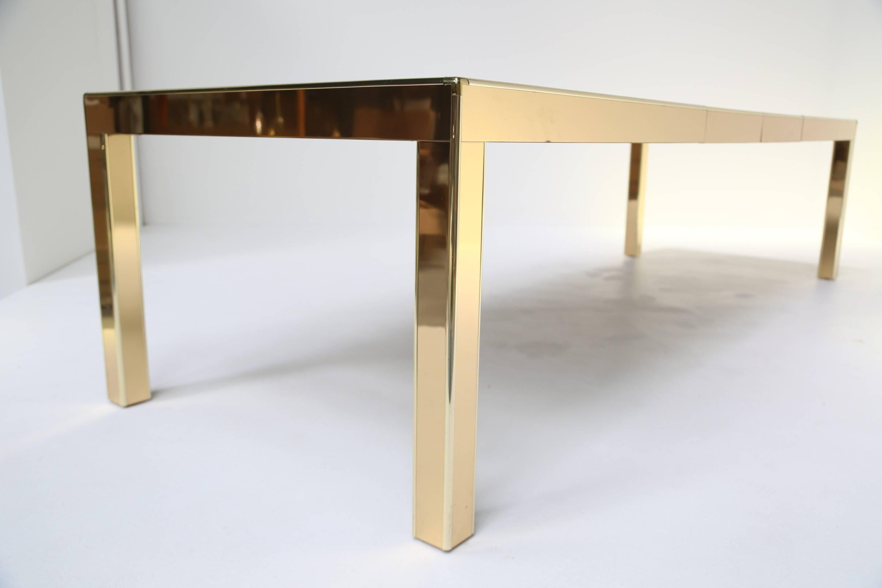 Mid-Century Modern Mastercraft brass extending dining table with mirrored glass panels.