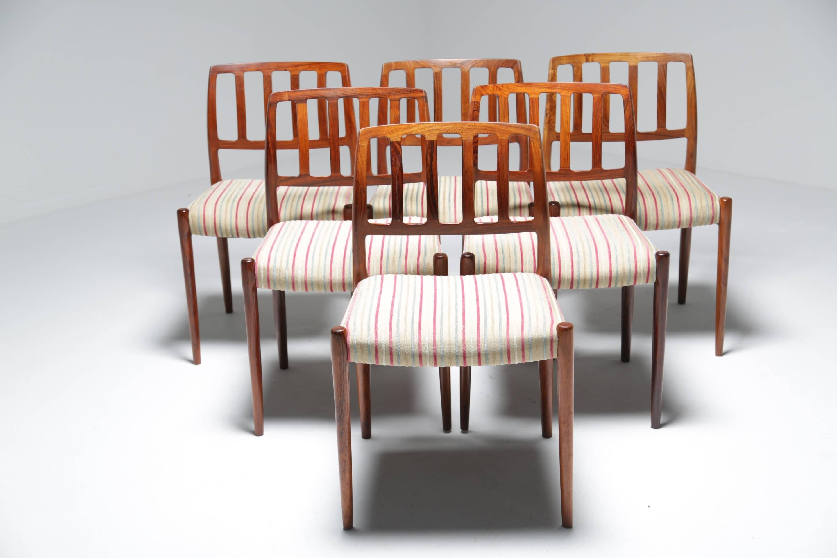 A beautiful set of six vintage Brazilian rosewood dining chairs designed by Niels O Moller. These are the much sought after model 83 chairs with a luxe stripe velour fabric upholstery. Ergonomically, Moller chairs are some of the most comfortable