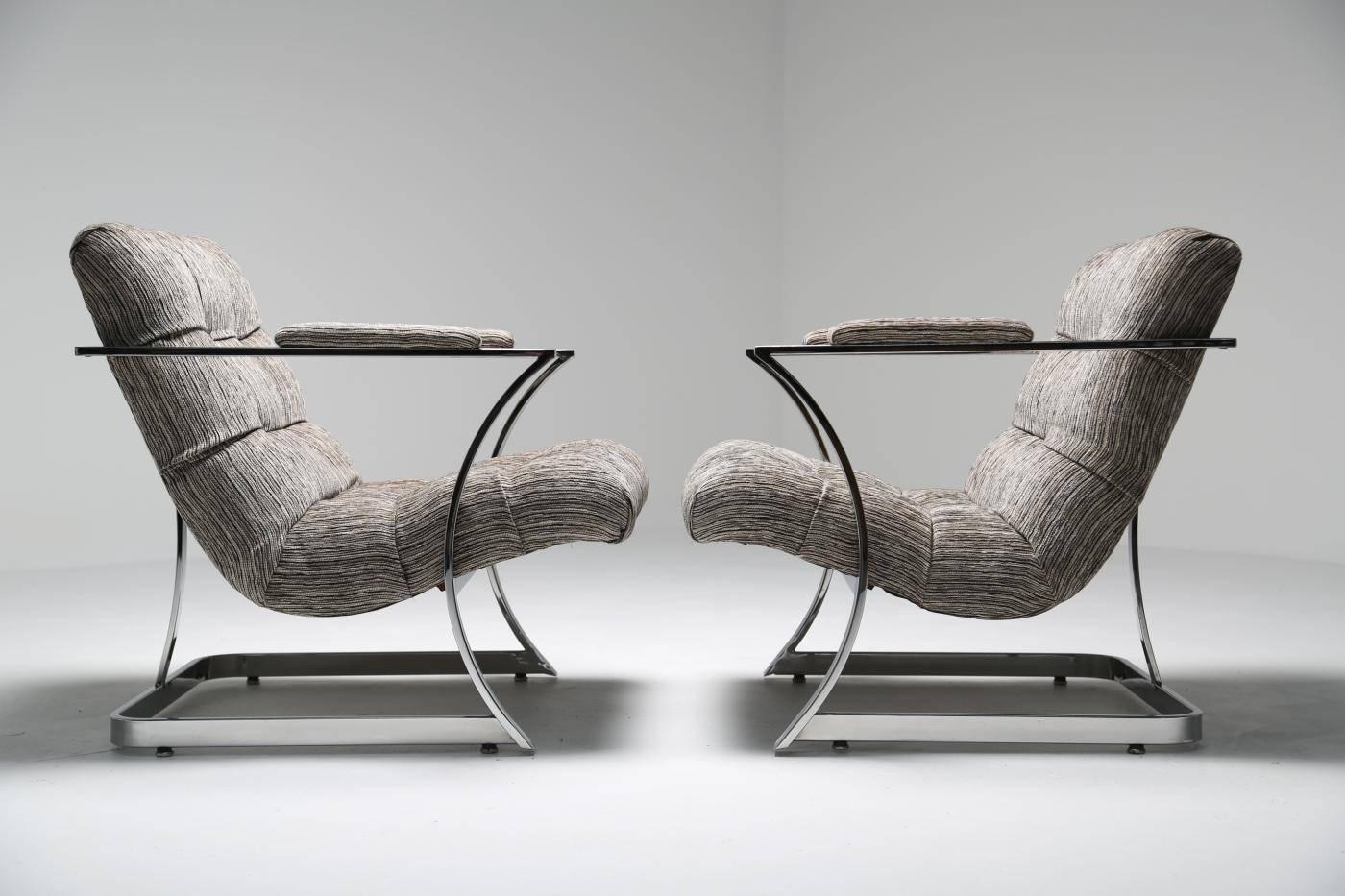 A pair of very sculptural chrome lounge chairs in the style of Milo Baughman. Made with curved flat bar chrome-plated steel and upholstered in a nubby grey fabric. Easily shipped anywhere in the world.