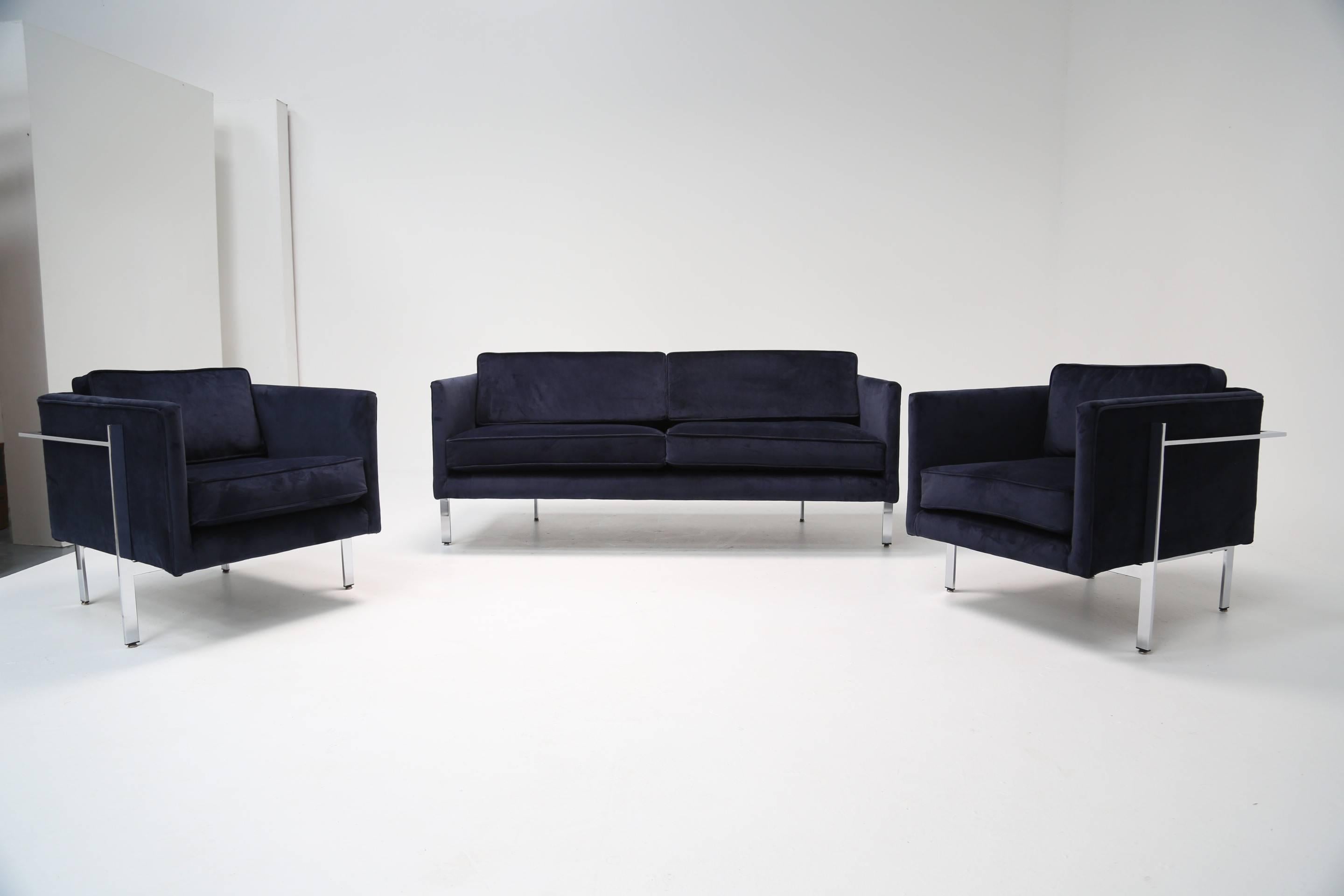 This stylish and elegant chrome framed two-seat sofa with a matching pair of armchairs is newly upholstered in a beautiful navy blue velvet. No labels but it is known as a 