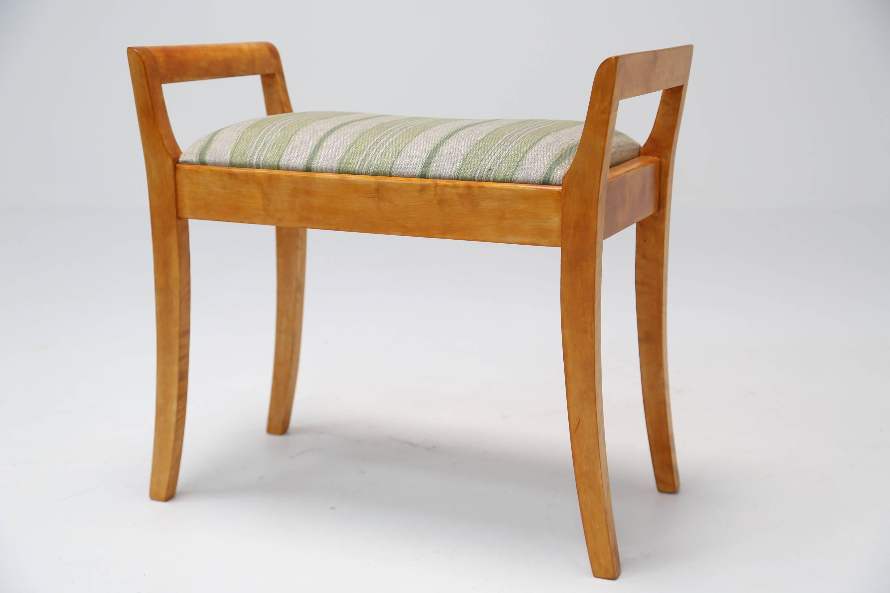 A simple yet elegant Midcentury Swedish stool with upholstered seat. The wood is beautifully smooth and has rich amber tones. Very easily shipped worldwide.