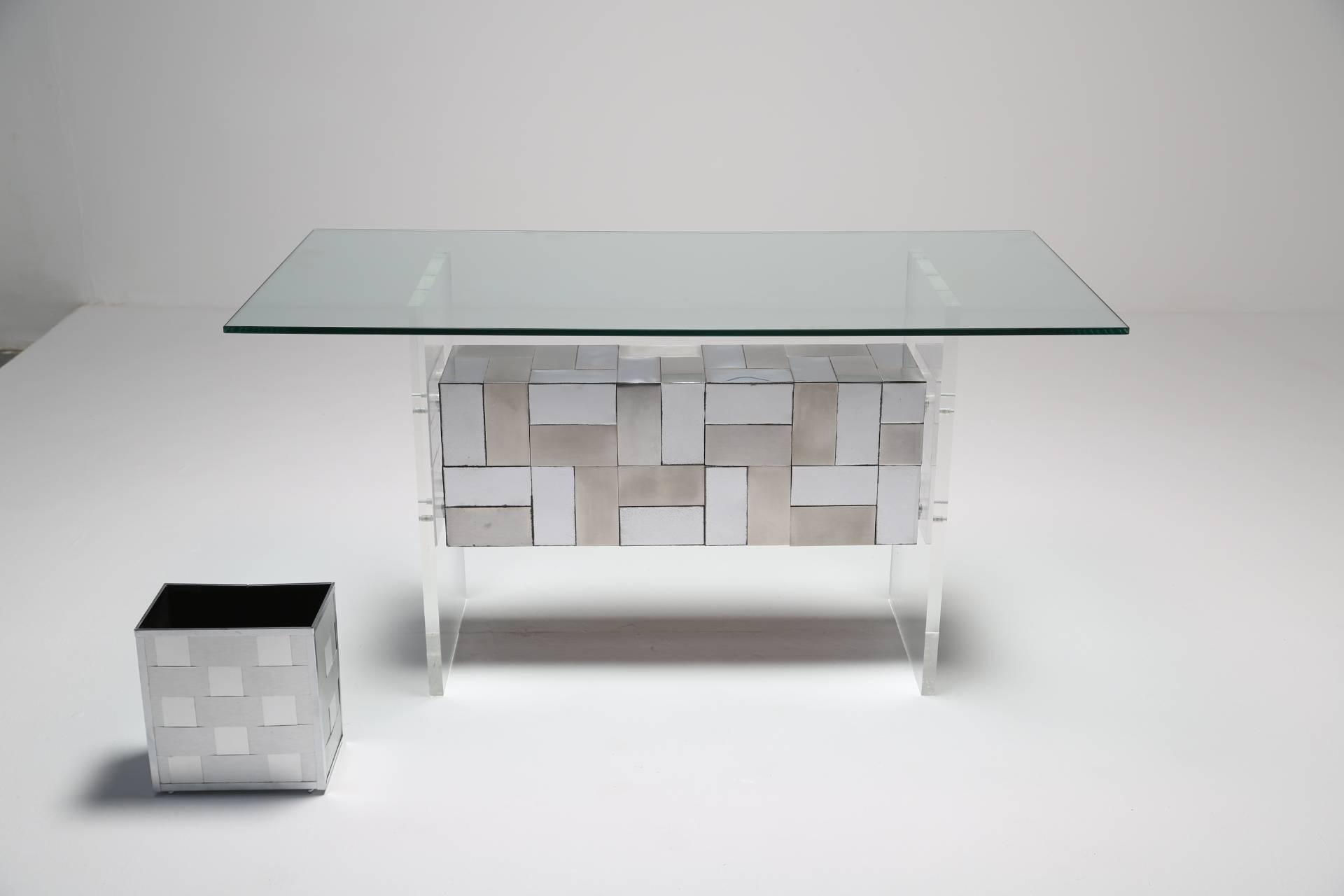 This striking 'cityscape' patchwork desk in Lucite, glass and chrome is designed in the style of Paul Evans and complimented by a wastepaper basket and desk tidy. The desk is set on a Lucite frame with a 'cityscape' style patchwork chrome tiled