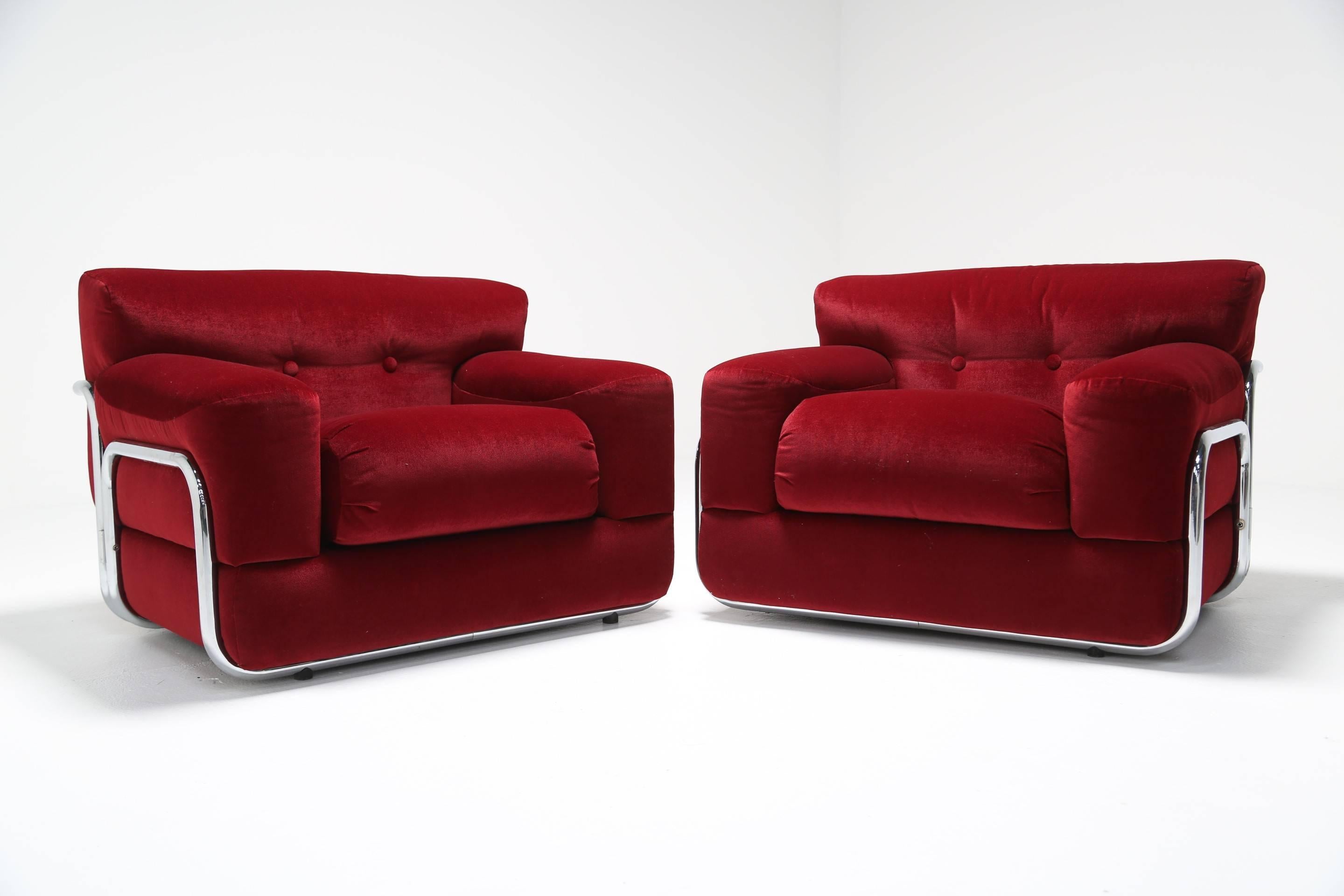 A handsome pair of large lounge chairs with a chrome tubular frame upholstered in a beautiful rich deep red velvet. They are incredibly comfortable and the chrome frame and deep cushions offers an interesting twist on the traditional armchair. Very