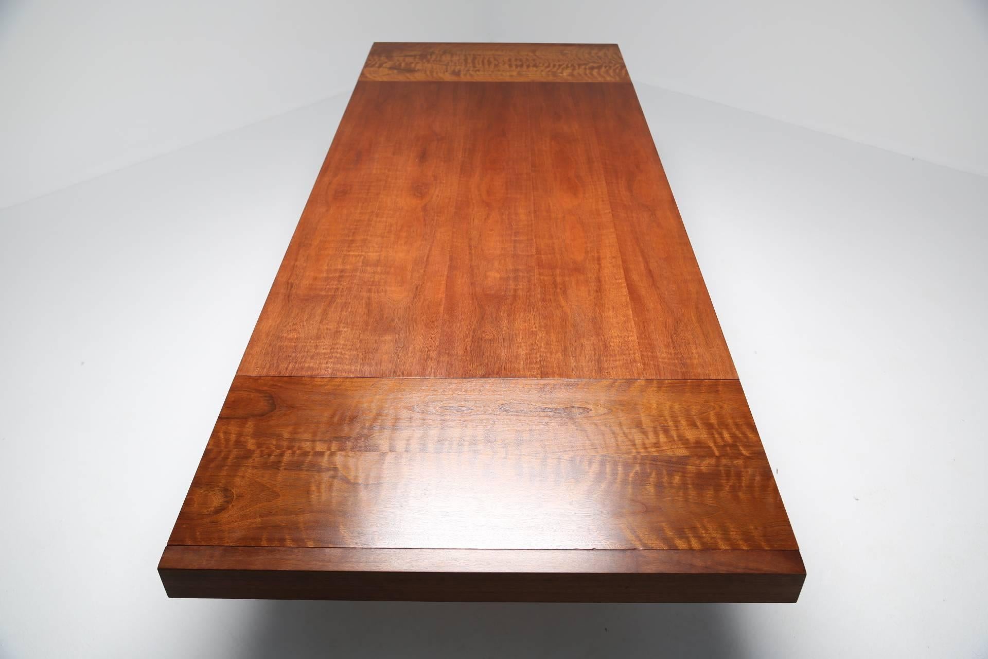 A walnut dining table designed and made by Founders furniture company circa 1975. The table top floats above the base and creates one of the best silhouettes of any dining table of this period.  The wood has lovely rich warm tones and good clear