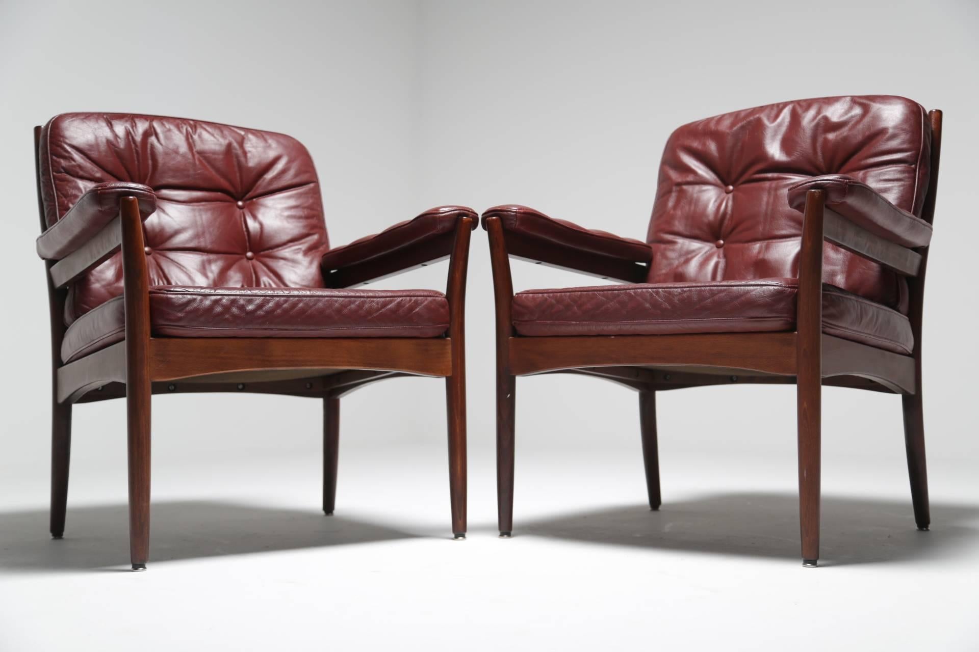 Gote Mobler of Nassjo, Sweden made this pair of gorgeous wine-coloured leather armchairs, circa 1970. They have a hardwood frame and the buttoned leather upholstery is beautifully soft and comfortable. The leather buttoning also extends to the arm