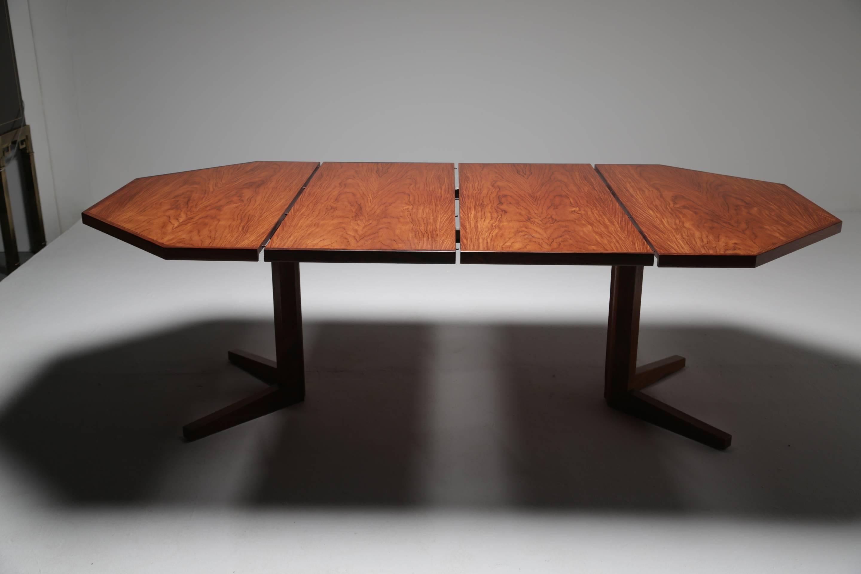 An unusual vintage rosewood dining table made by the Danish factory Dyrlund. This midcentury dining table is octagonal in shape and comes with two extending leaves which cleverly bring the table from a four-seat breakfast table to a six or