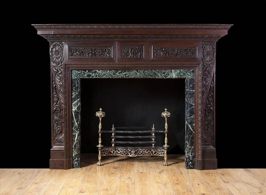 English antique carved wooden fireplace from a fine London property. In the Renaissance revival style, with exquisitely carved panels and mouldings of festoons, laurels and leaf-work. The fireplace is of excellent quality and produced in teak, a