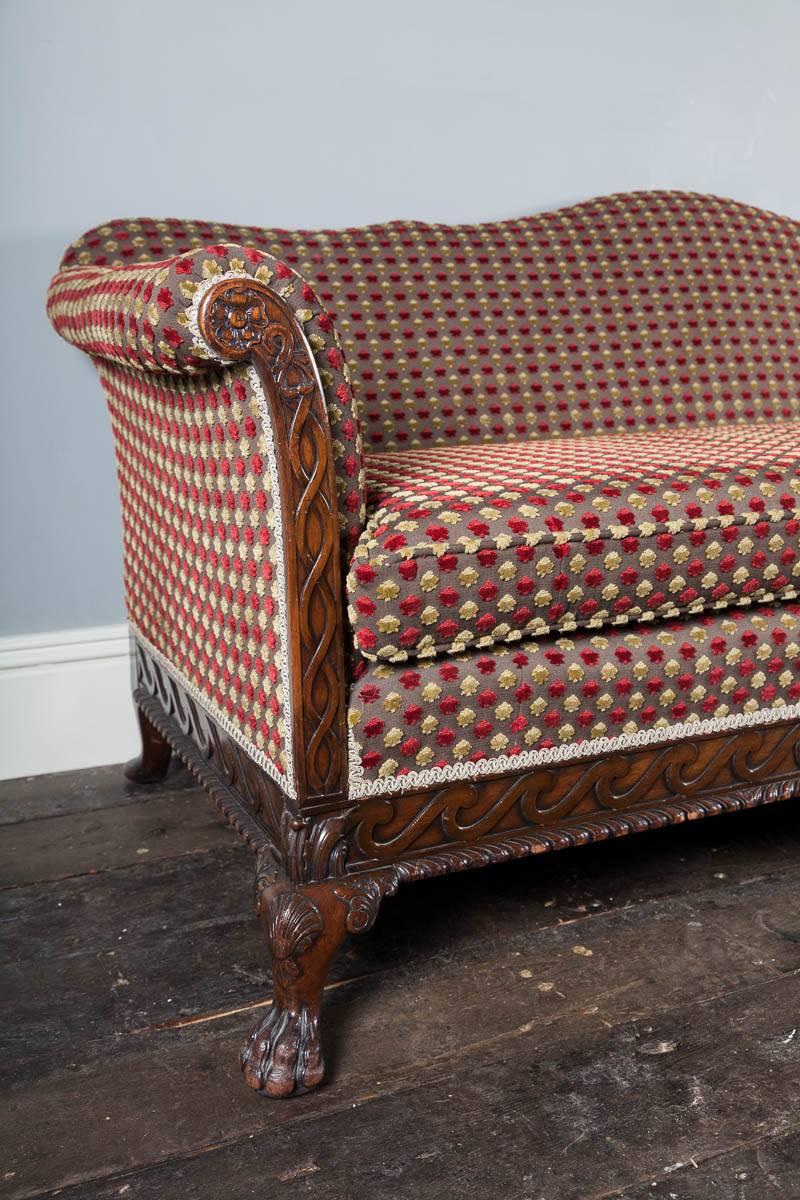 Antique George II revival mahogany and upholstered settee. With a carved Vitruvian scroll frieze resting on hairy paw feet with clam shell knees.

Re-upholstered in a stylish designer fabric.

 