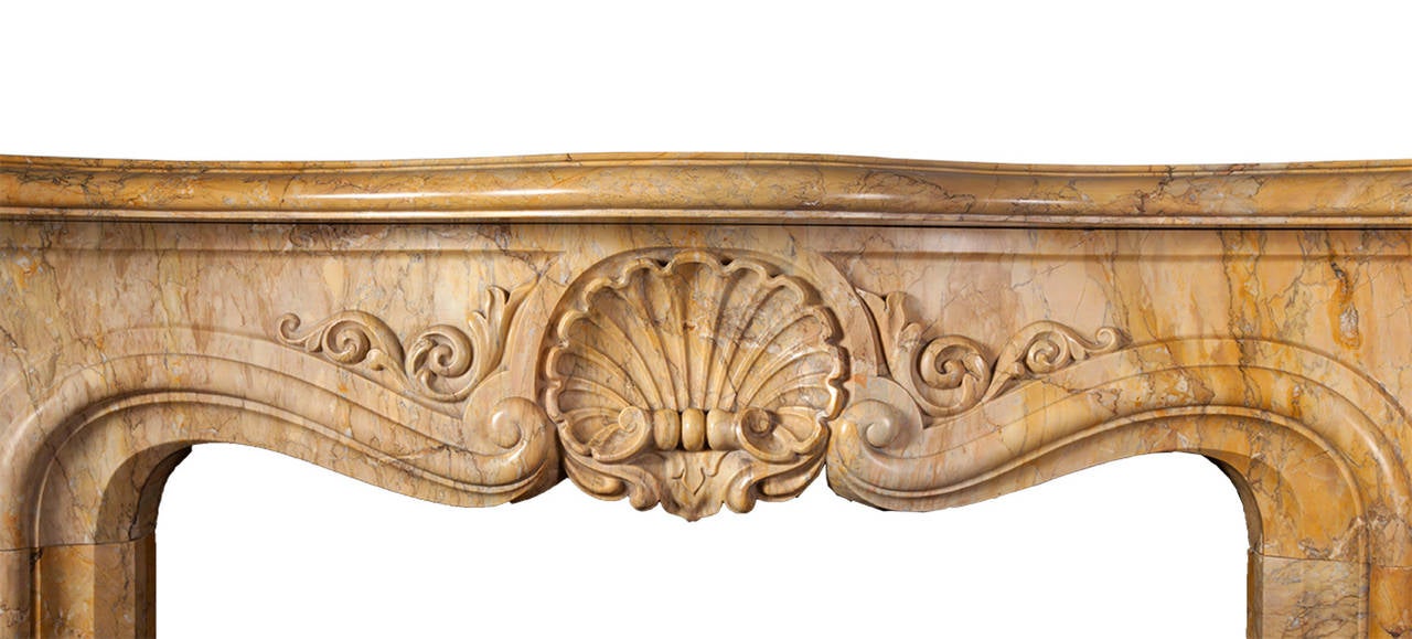 A most stunning Sienna marble chimneypiece in the Rococo Revival style.

A large shell cartouche is flanked by scrolled foliage on raised and fielded panels. The angled cabriole jambs are decorated with acanthus leaves on the front and sides. The