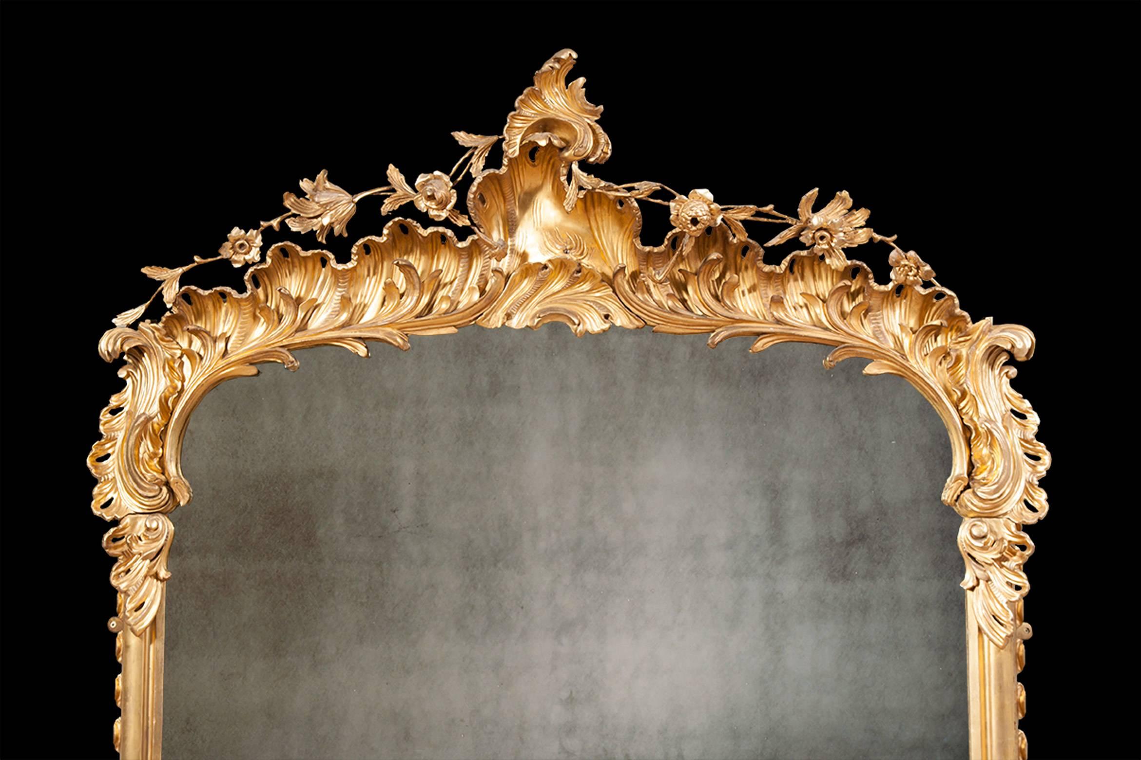 An exceptional matching pair of mid-19th century Irish giltwood overmantel mirrors. With ornate floral crests, elaborate acanthus leaf decoration and crisp carvings throughout. These mirrors would sit very comfortably on either fireplace mantels or