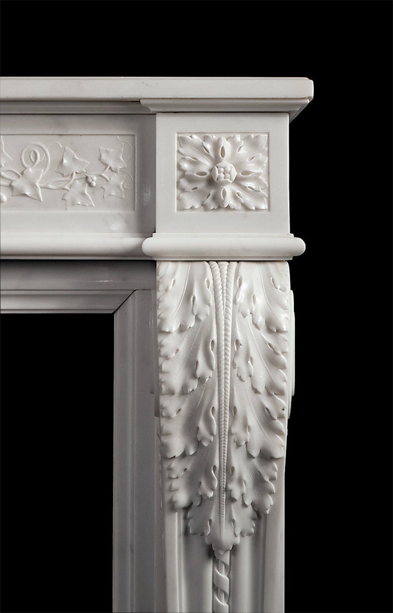 A finely carved white marble fireplace in the French Louis XVI style. The acanthus consoles taper and terminate with carved plinth mouldings. The running frieze carved with ivy vines and berries tied with ribbon in the centre.