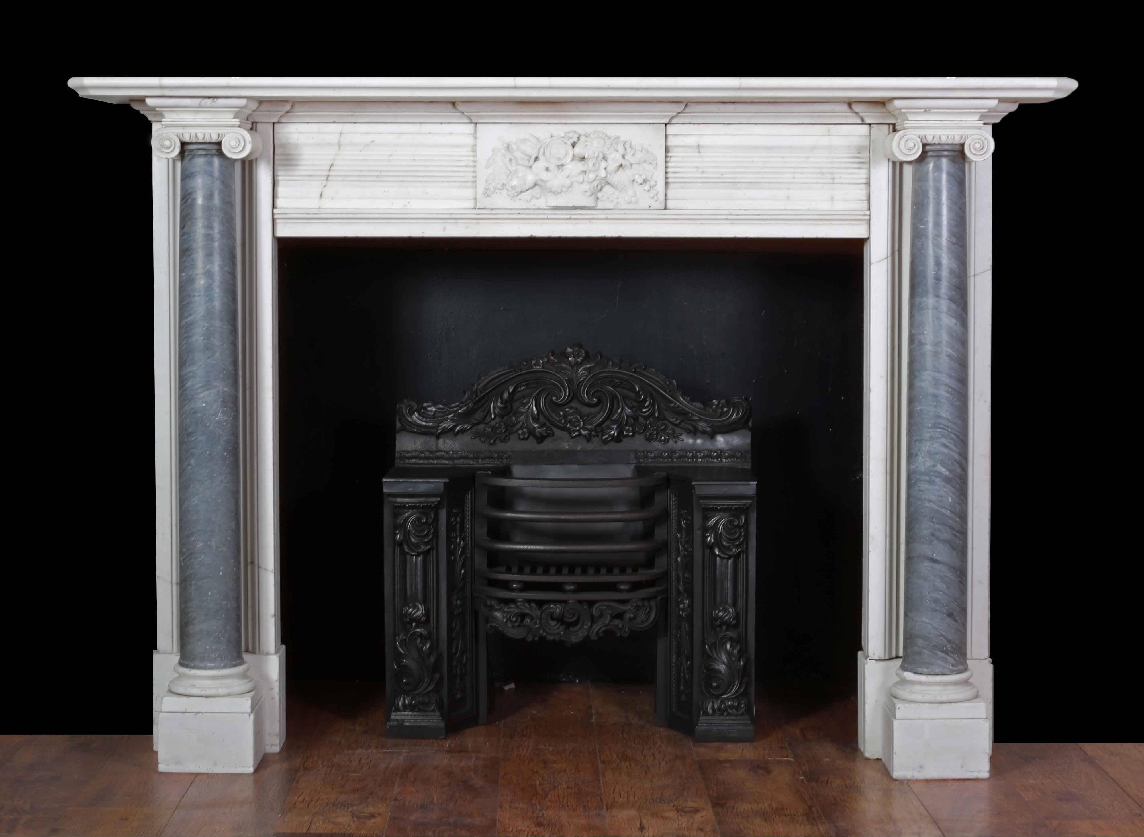 An attractive marble fireplace from the Regency period (1820s). Made from Italian white statuary and grey bardiglio marbles.

The jambs with tapering Ionic full rounded columns, supporting a rectangular moulded shelf. The centre plaque finely