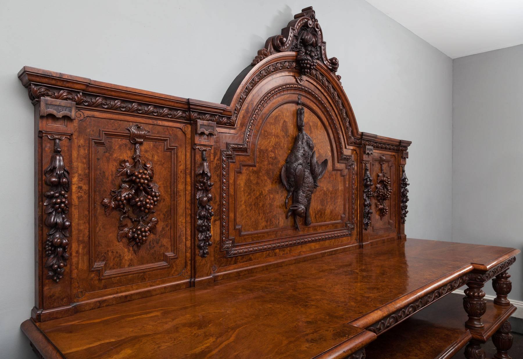 Large antique pollard oak sideboard of exceptional quality and great architecture form.
This wonderful sideboard, server or buffet boasts exquisitely carved elements and eye-catching pollard oak veneers. The arch topped back is carved with a hunt
