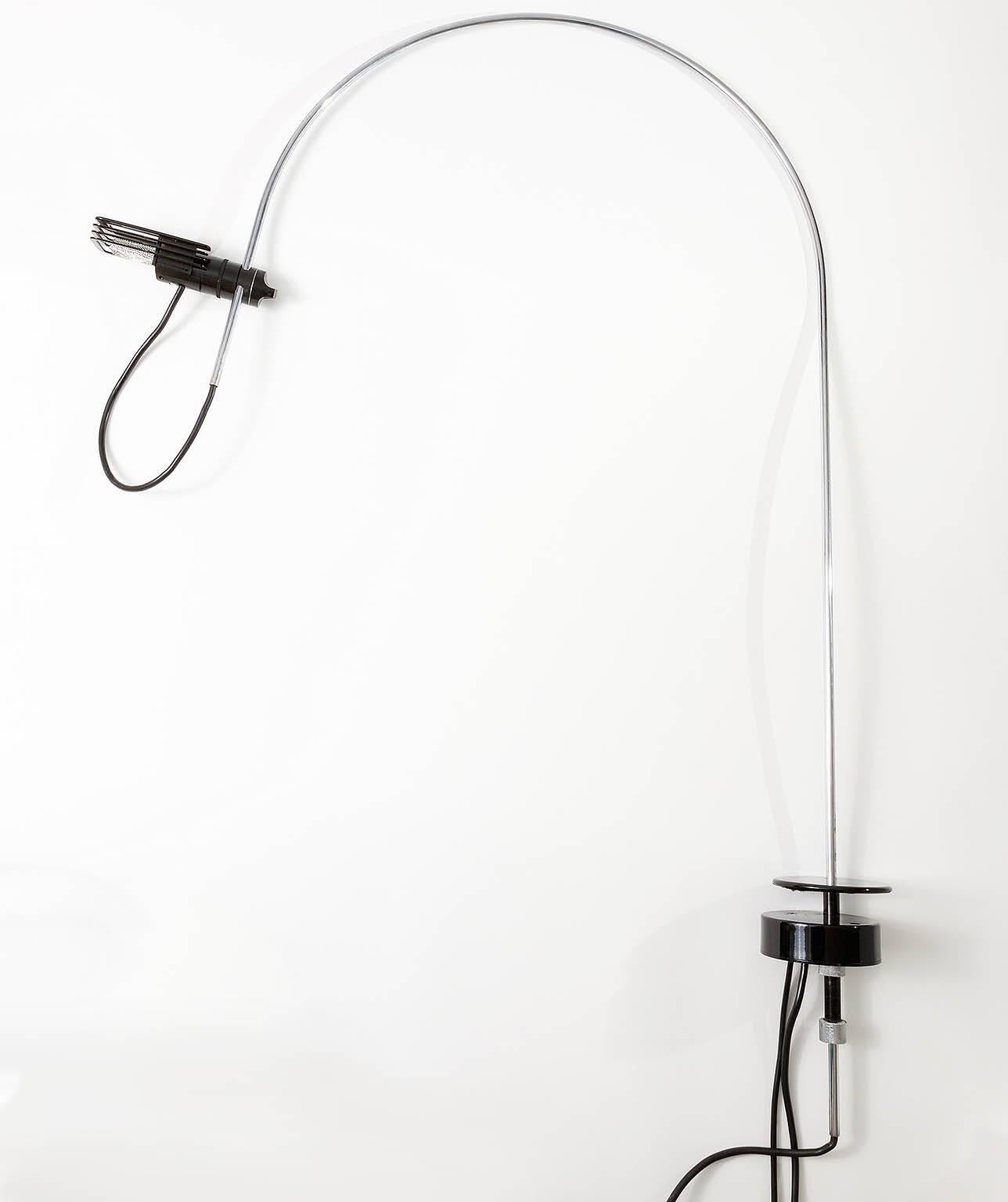 Rare wing table or desk lamp designed in 1973 by Bruno Gecchelin for Italian maker Oluce, Milan. Chrome-plated tubular steel, black plastic, base painted black. Halogen bulb. Wear on mounting device (please see images).