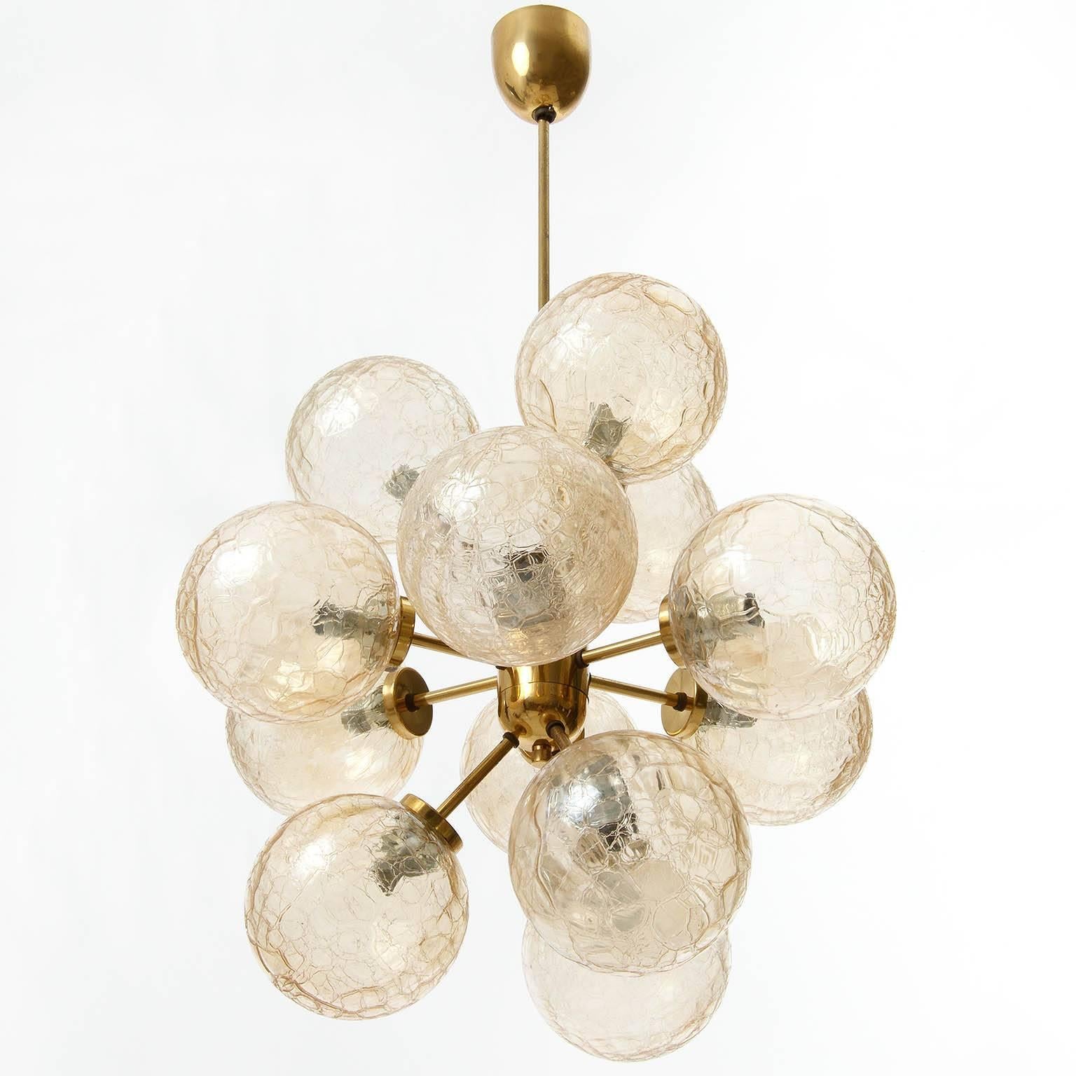 A twelve-arm Sputnik chandelier manufactured in Mid-Century in 1970s. It is made of brass and handblown amber tone craquele glass lamp shades.
Nice patina on brass.

Diameter: 21