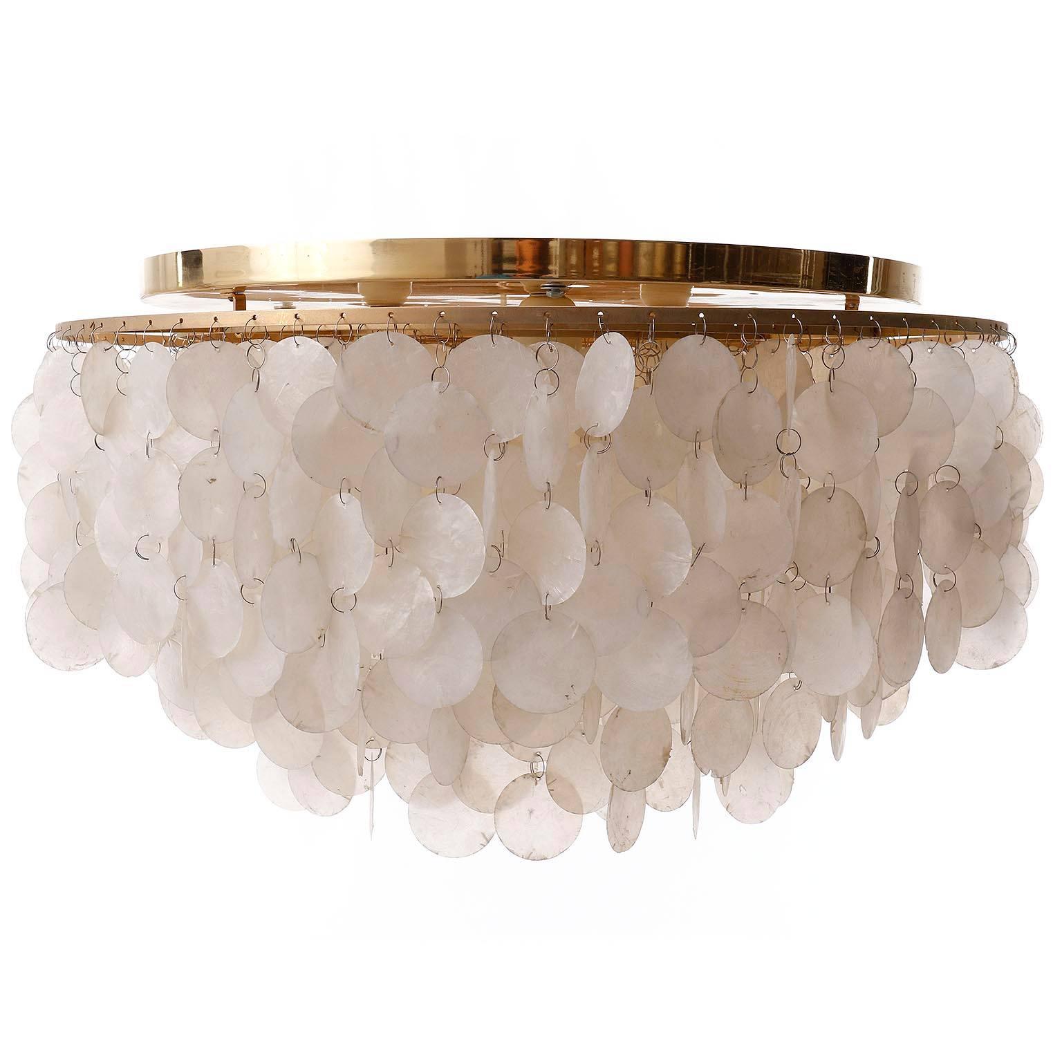 A large four-tier sea shell flush mount light fixture designed by Verner Panton for the Swiss manufacturer J. Luber Ag. An original vintage piece manufactured in Mid-Century (1960s-1970s).
Hundreds of sea shells are hanging on four rings of brass.