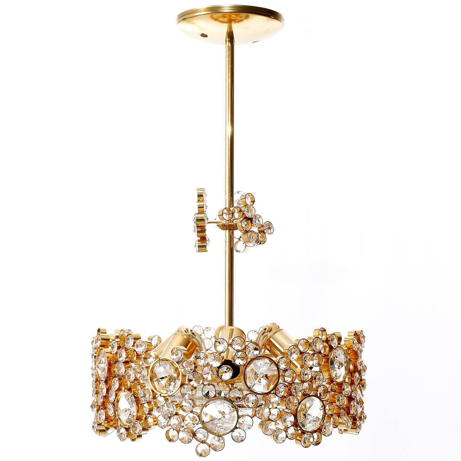 A gorgeous and high quality gold-plated brass chandelier or pendant light by Palwa (Palme & Walter), Germany, manufactured in Mid-Century, circa 1960. Hundreds of gilded brass rings with cut-glass crystals in different sizes. A round textured glass