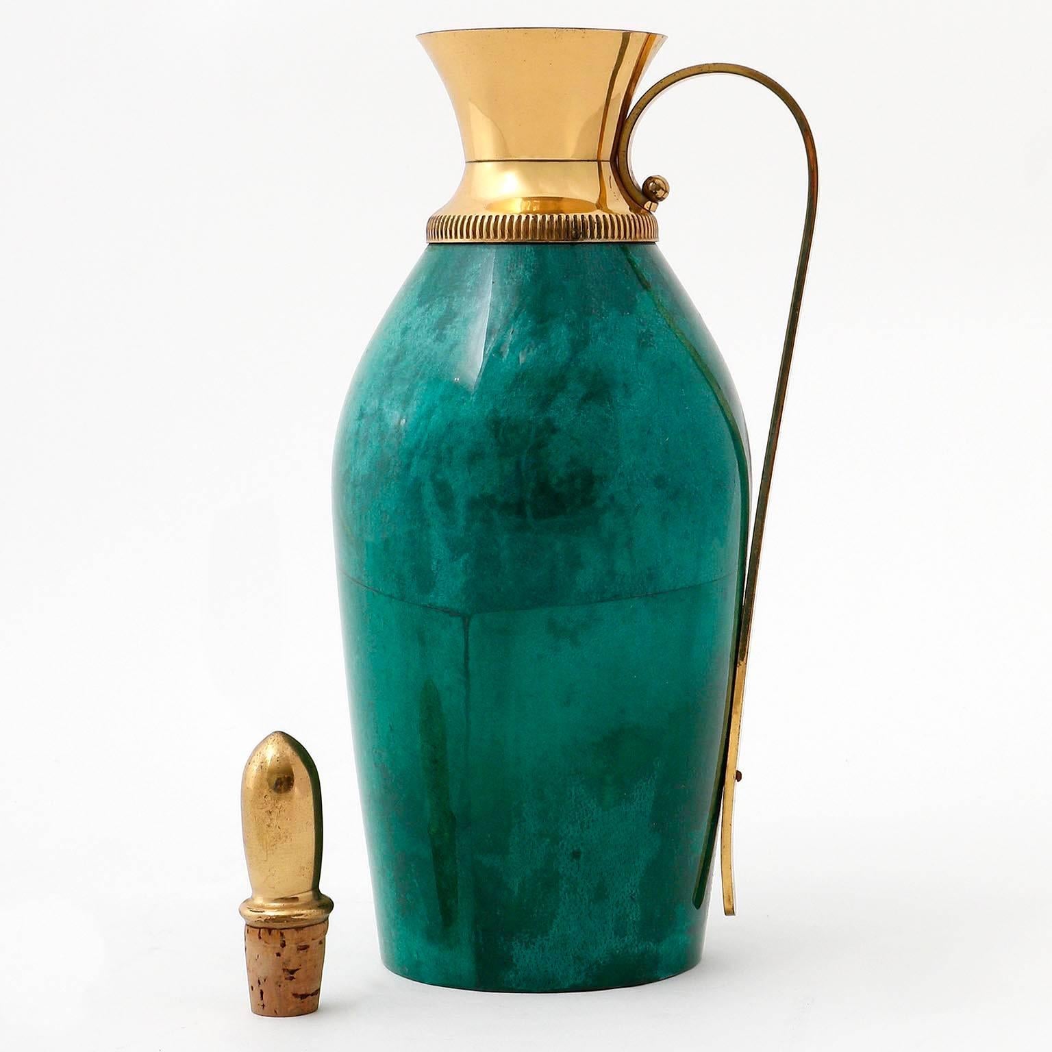 An Italian carafe in lacquered emerald green goatskin with brass details by Aldo Tura for Macabo, manufactured in Mid-Century, circa 1960 (late 1950s or early 1960s).
The bottle is labeled on the bottom.