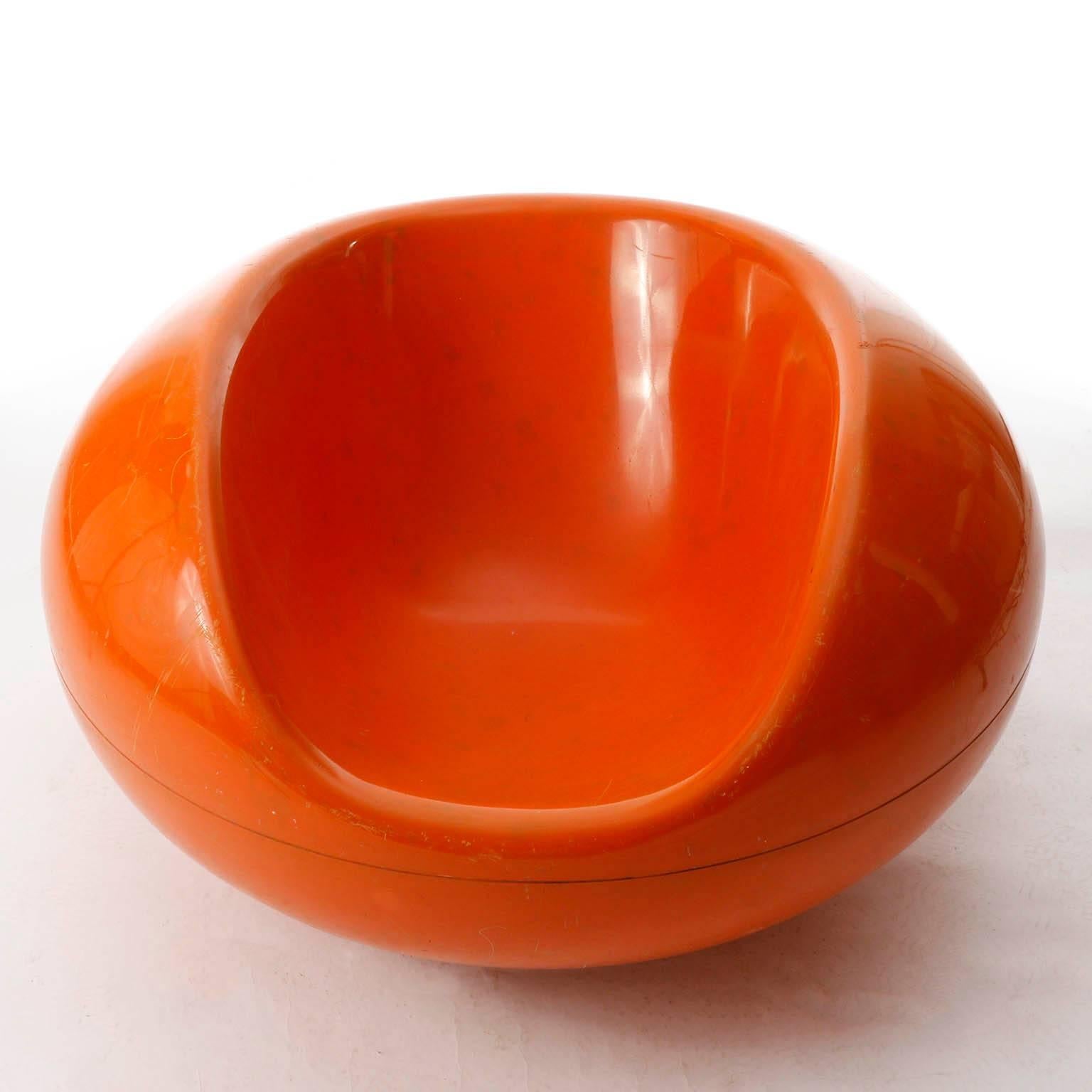 Una sedia in fibra di vetro arancione lucido 