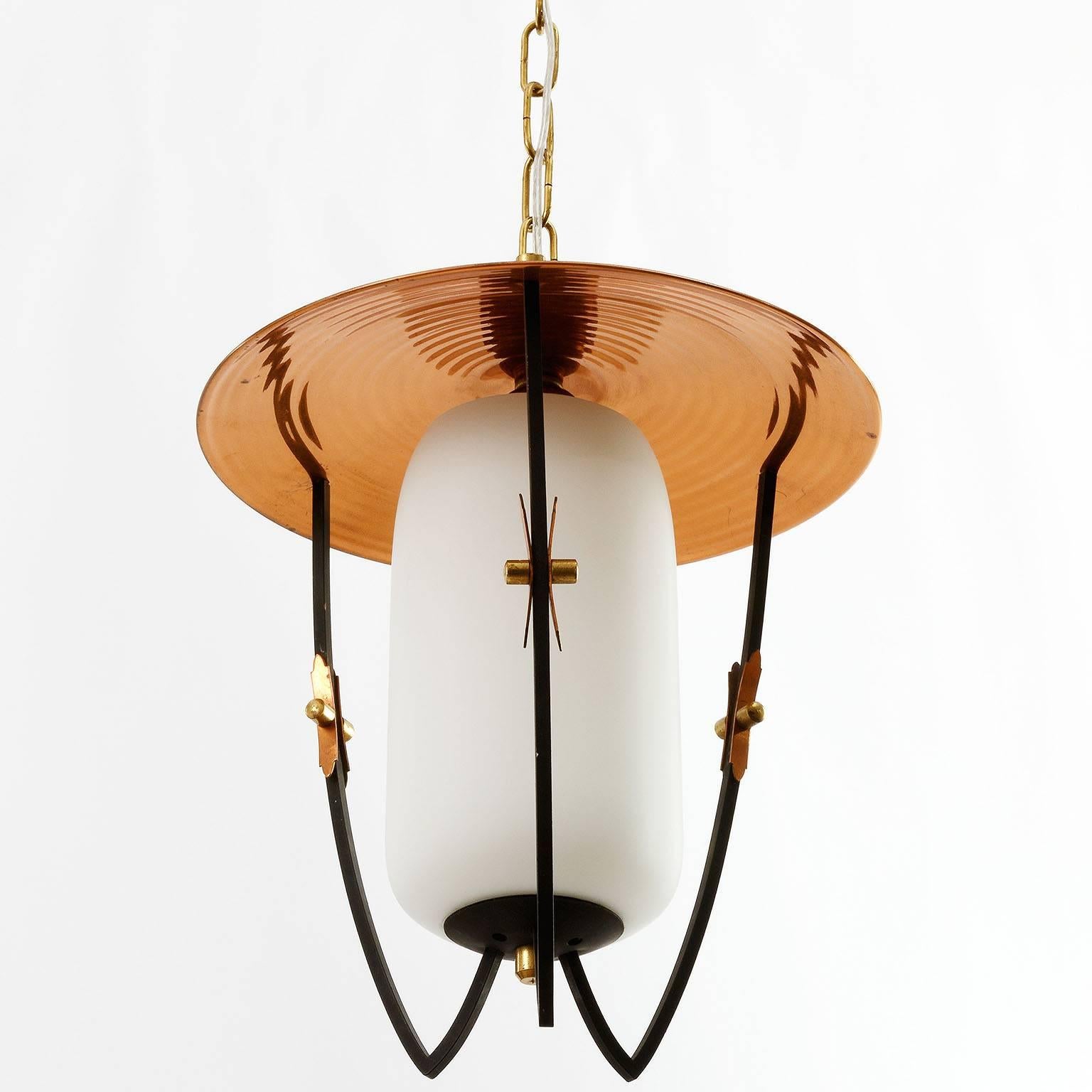 A set of three nice lanterns or pendant lights by Rupert Nikoll, Austria, manufactured in midcentury, circa 1960 (late 1950s or early 1960s).
There is lovely patina on brass and copper. 
A nice mixture of materials and colors: white, black, brass,
