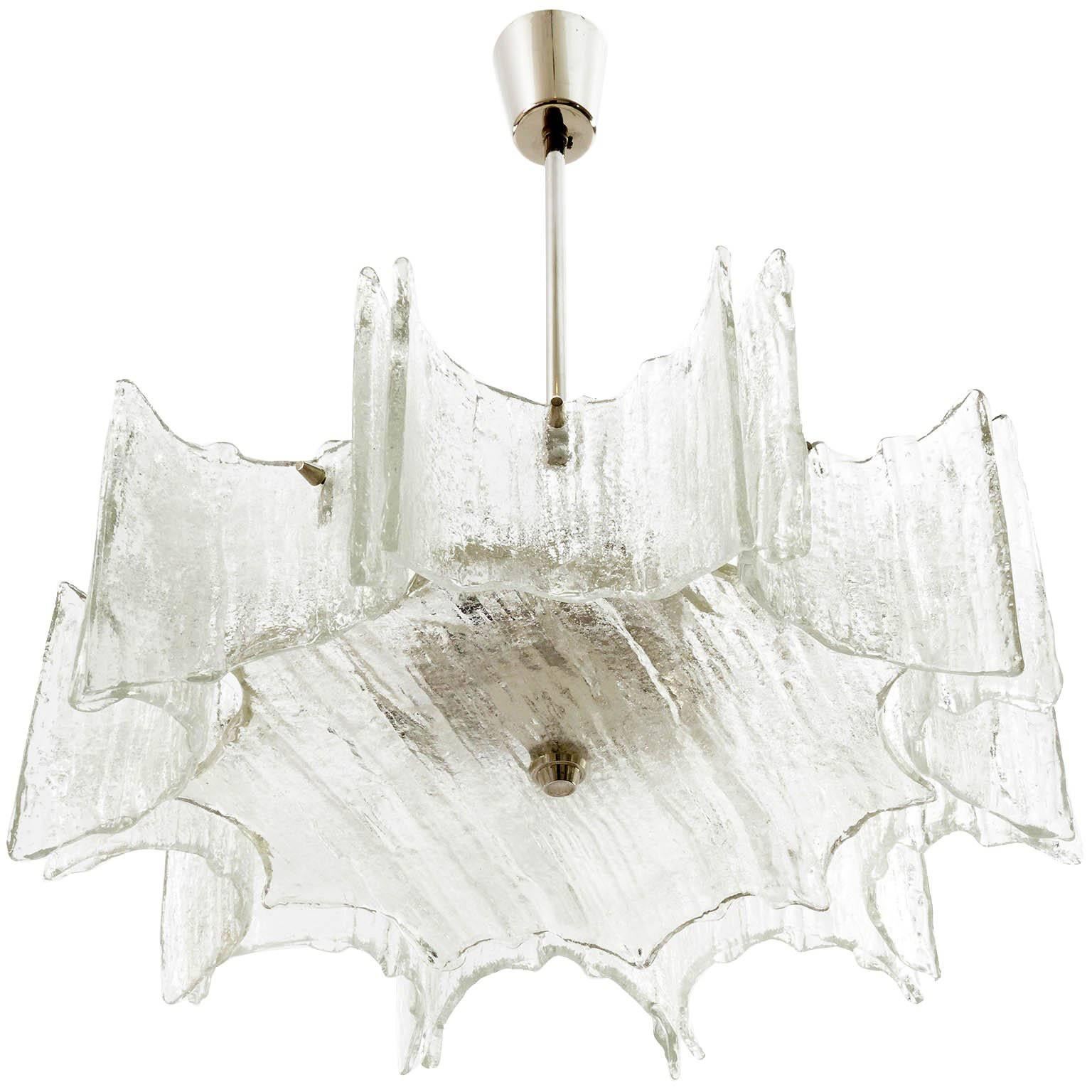 A pair of star shaped ceiling lights by Kalmar manufactured in Austria in midcentury, circa 1970 (late 1960s or early 1970s).
They are made of frosted ice glass pieces mounted on a white lacquered frame and a nickel-plated brass stem and canopy.
The